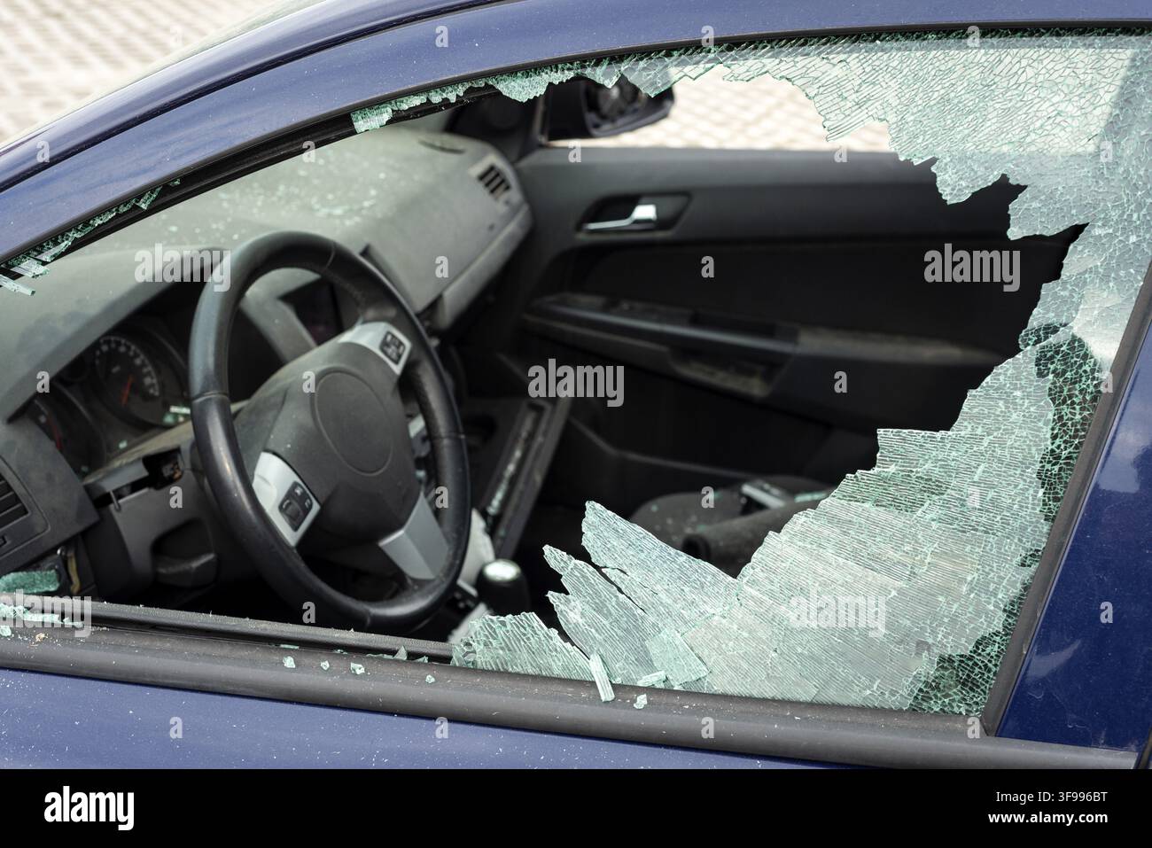 Vandalised car with a smashed broken side window Stock Photo
