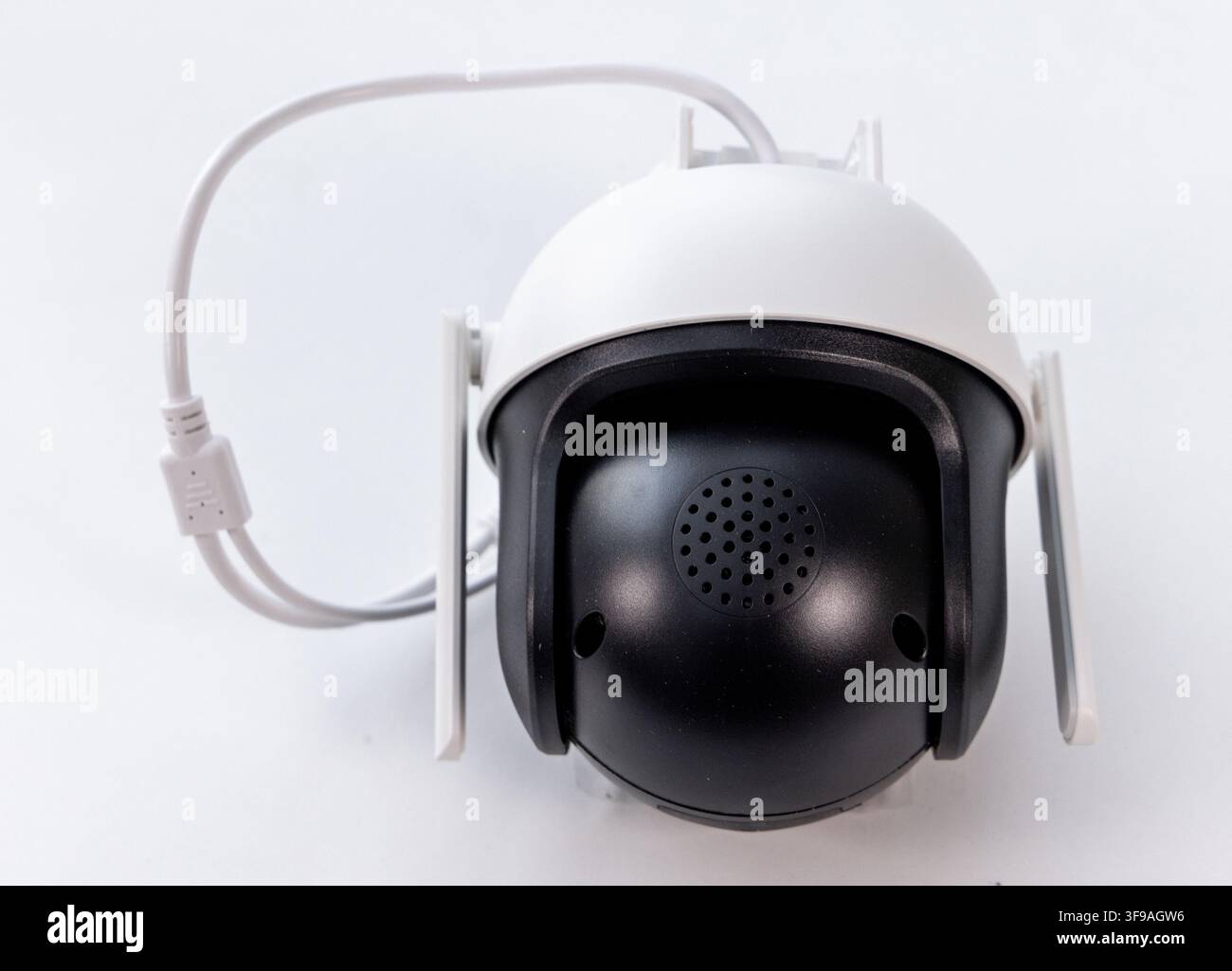 A white and black wireless security camera is shown on a white background Stock Photo
