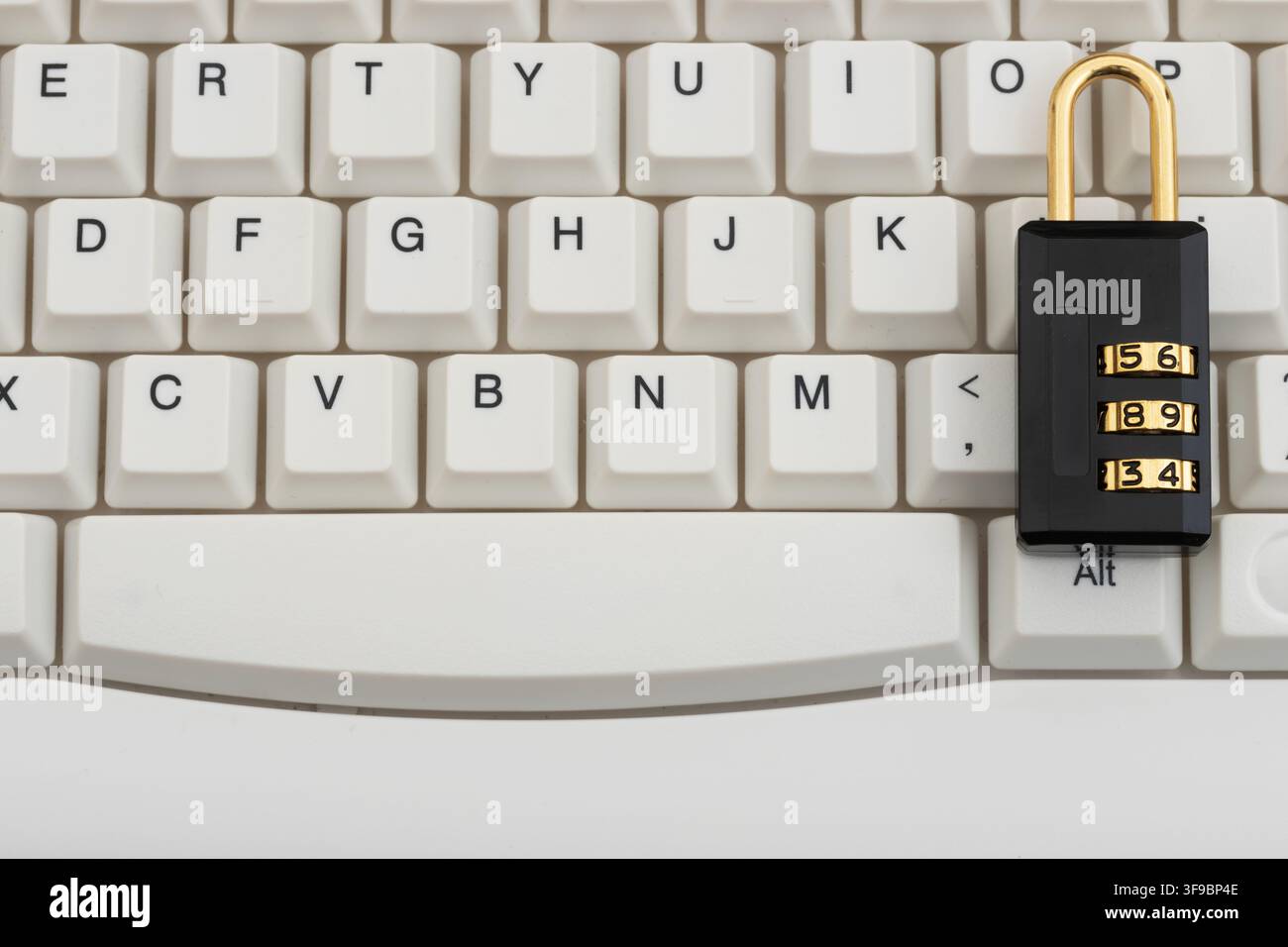 Combination lock on a white computer keyboard for data protection and cybersecurity Stock Photo