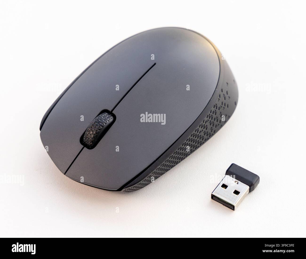 A wireless computer mouse and USB receiver are on a white background Stock Photo