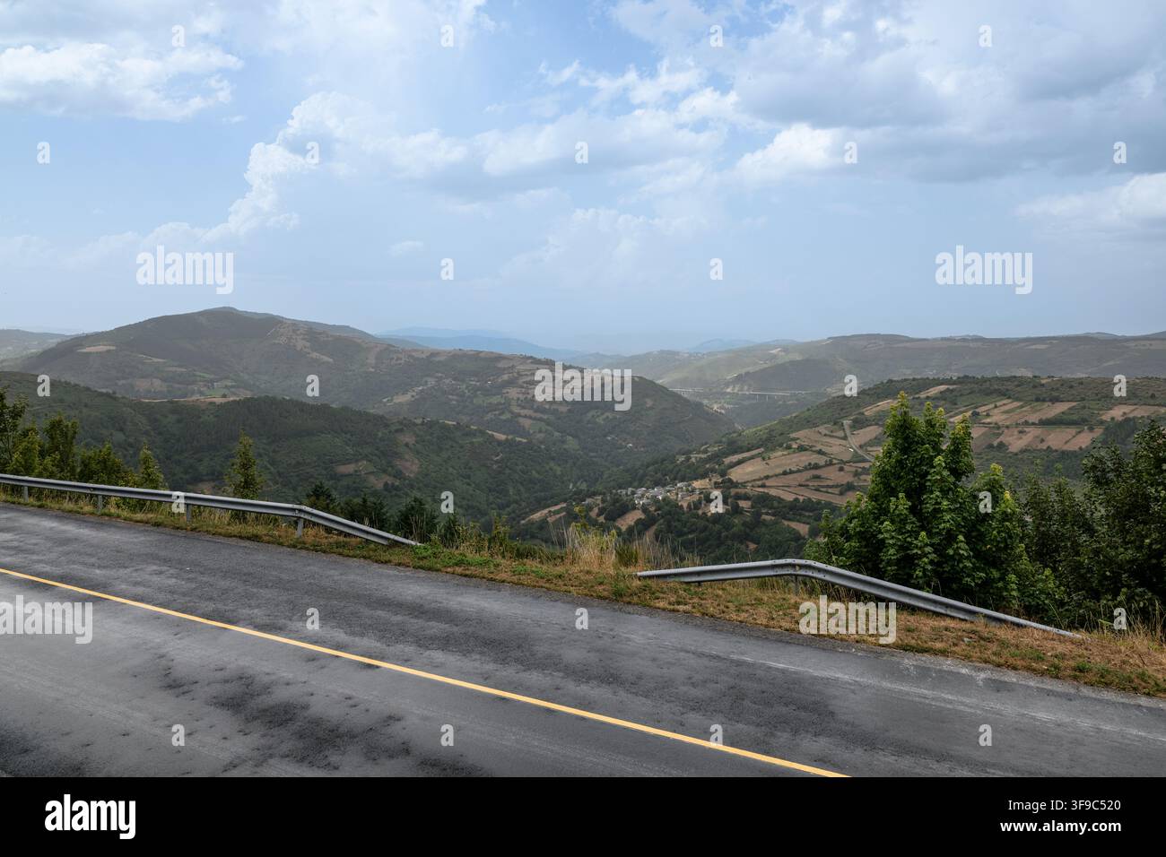 Winding mountain road passing through green valleys Stock Photo