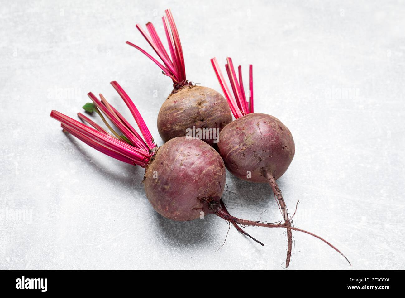 Whole young beets on gray textured table, closeup Stock Photo