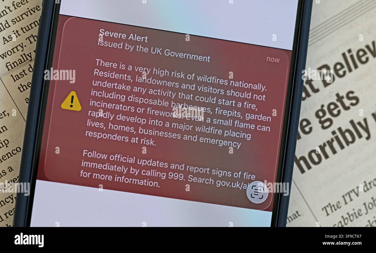 UK Government Severe Alert on a smartphone warning of very high wildfire risk nationally during the hot, exceptionally dry summer of August 2026 Stock Photo