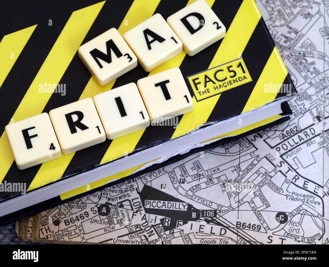 Mad Frit Madchester and Factory Records wordplay with letter tiles on a Manchester map - MadFrit Stock Photo