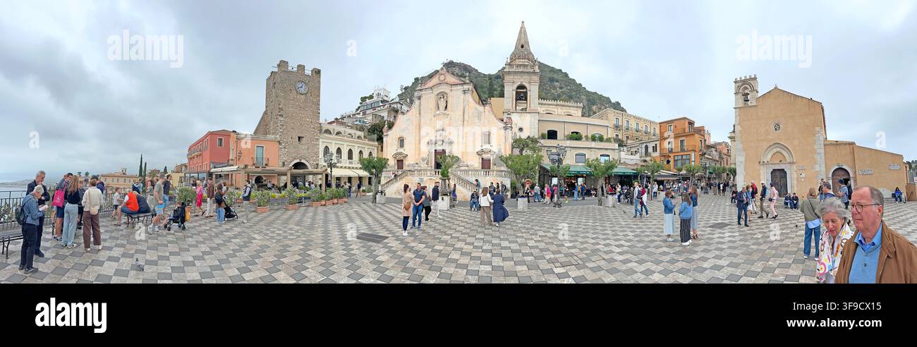 Visitors in Piazza IX Aprile, Taormina, Sicily, Italy, with San Giuseppe church and historic buildings in a panoramic town-centre view. Stock Photo
