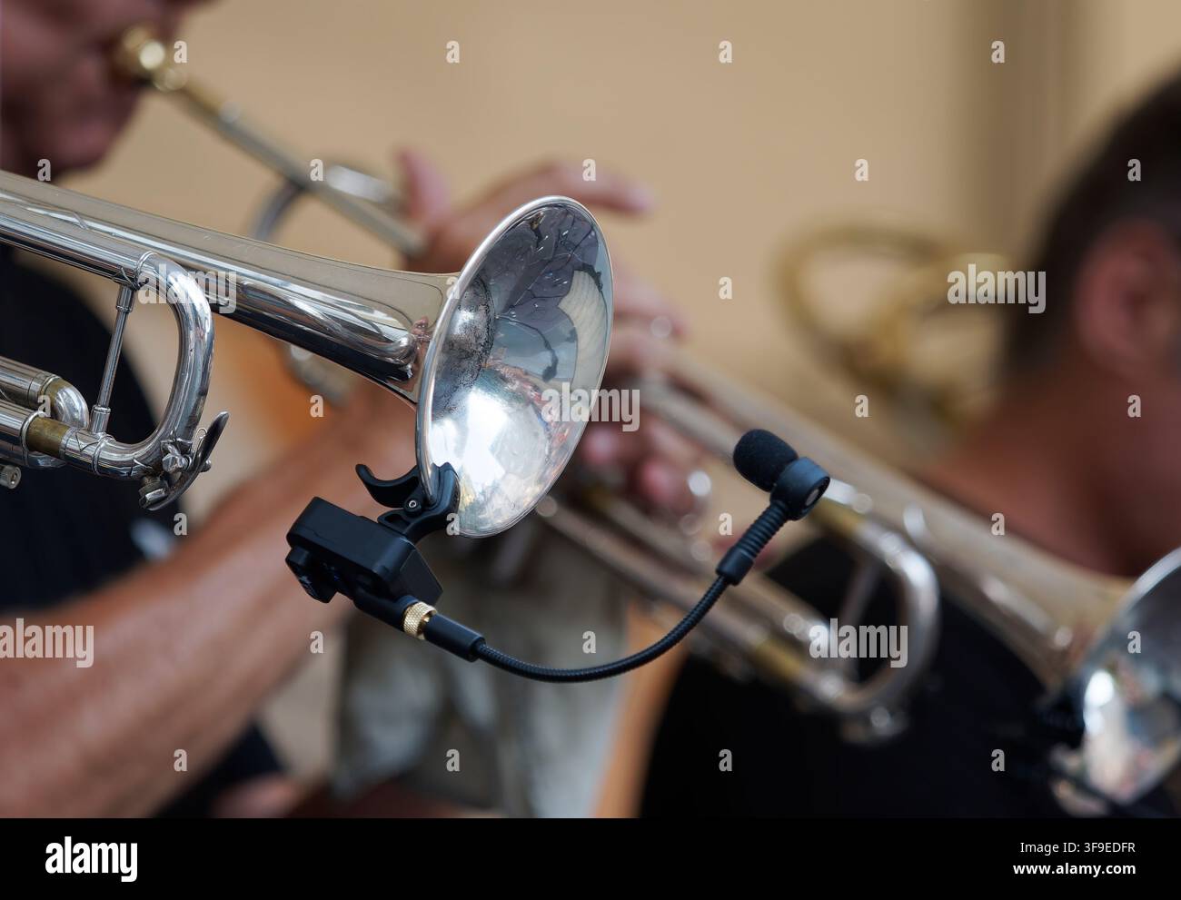 Close-up of a trumpet bell with a clip-on microphone during a live performance. Stock Photo