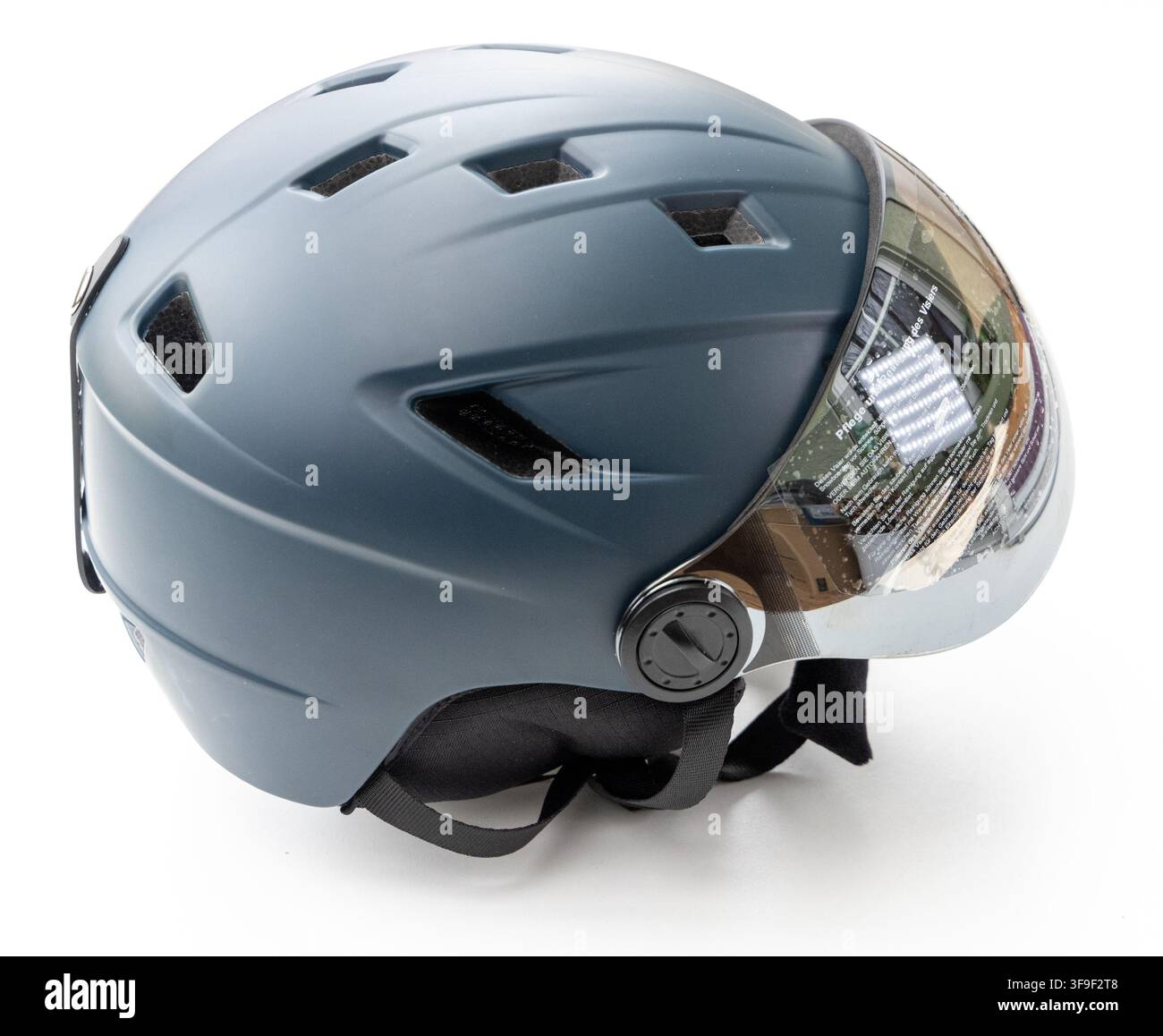 A greyblue multisport helmet with visor sits on white background Stock Photo