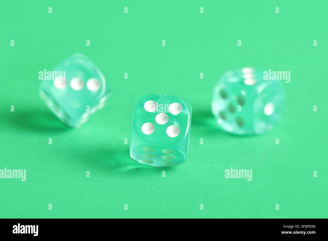 Turquoise game dices on green background Stock Photo