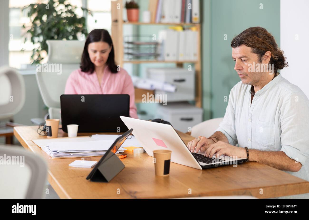 Middle-aged man working with laptop in modern office Stock Photo
