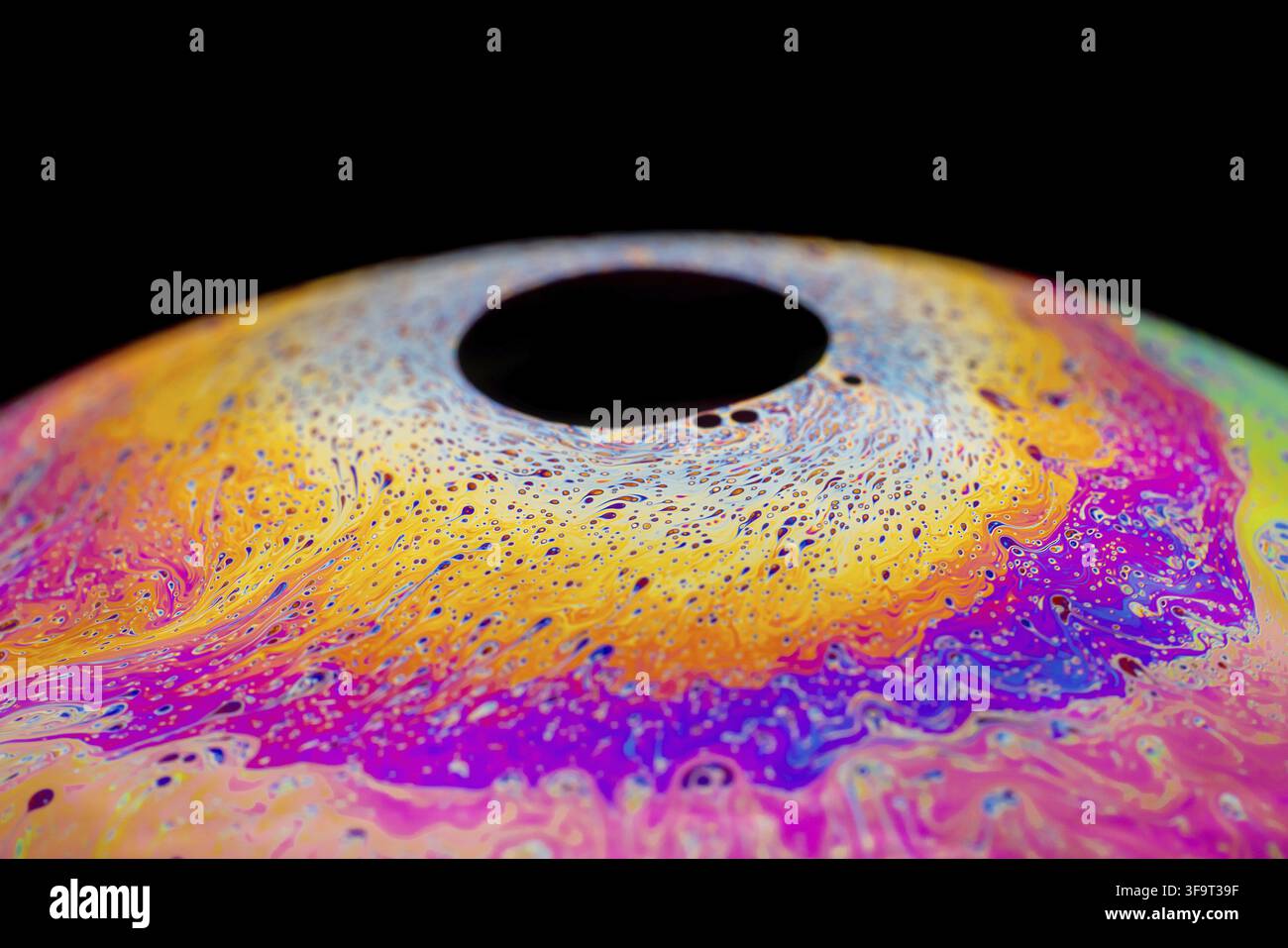 Multicolored abstract chaotic pattern inside of the soap bubble, closeup. Stock Photo