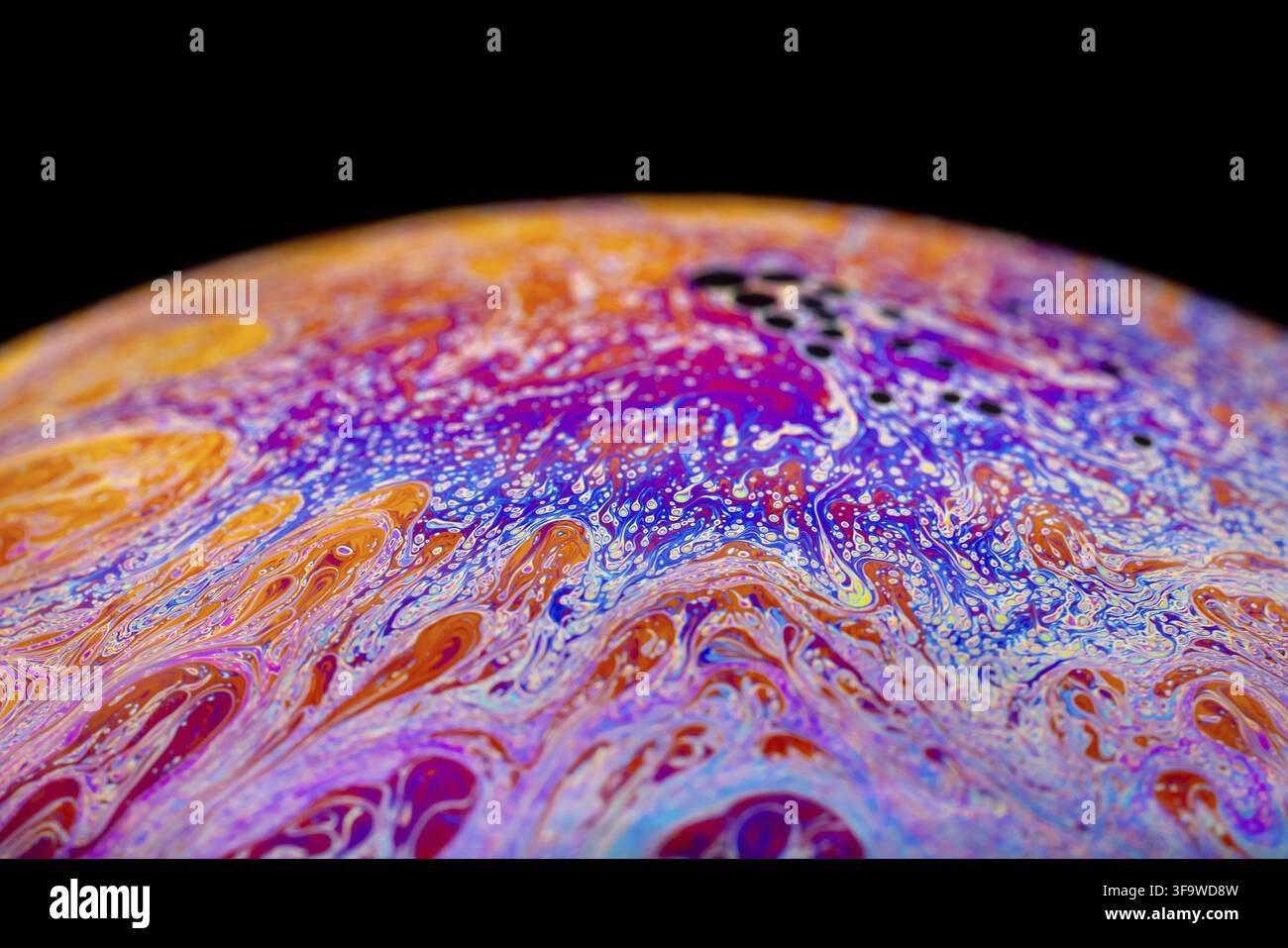 Multicolored abstract chaotic pattern inside of the soap bubble, closeup. Stock Photo