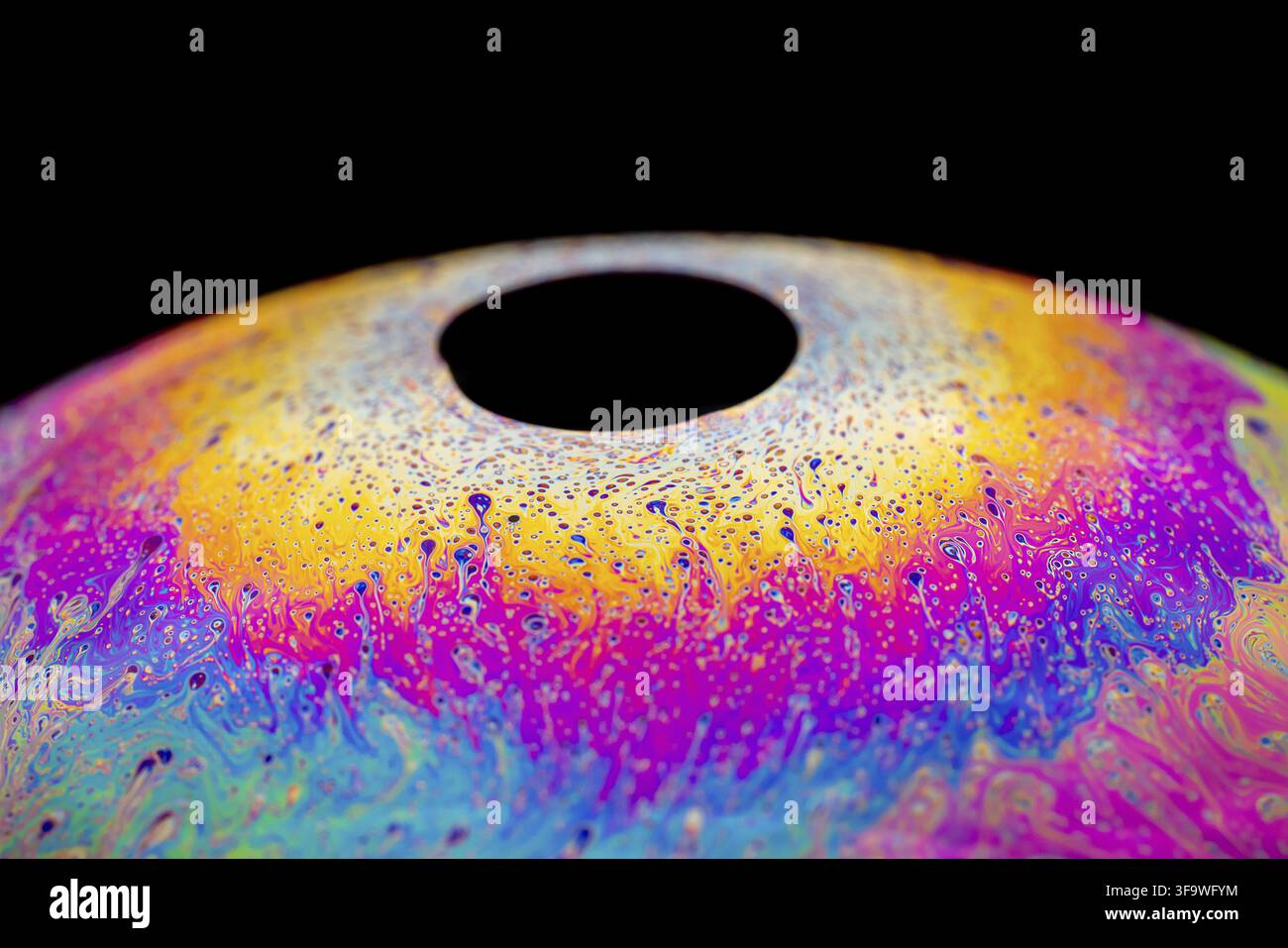 Multicolored abstract chaotic pattern inside of the soap bubble, closeup. Stock Photo