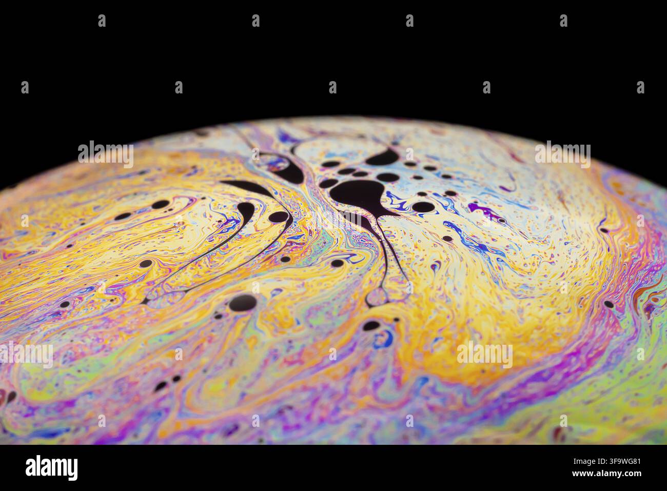 Multicolored abstract chaotic pattern inside of the soap bubble, closeup. Stock Photo