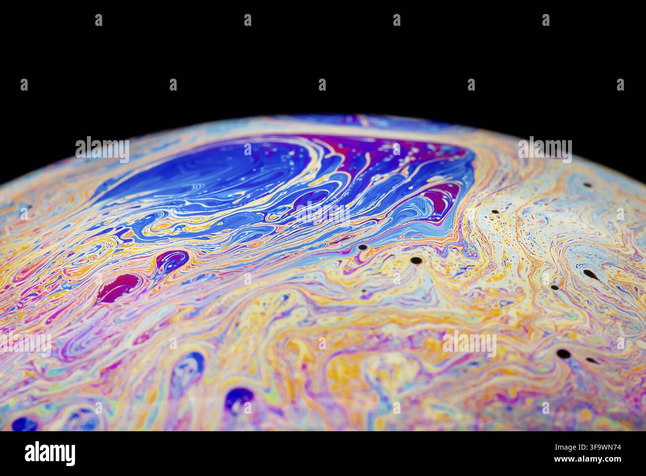 Multicolored abstract chaotic pattern inside of the soap bubble, closeup. Stock Photo