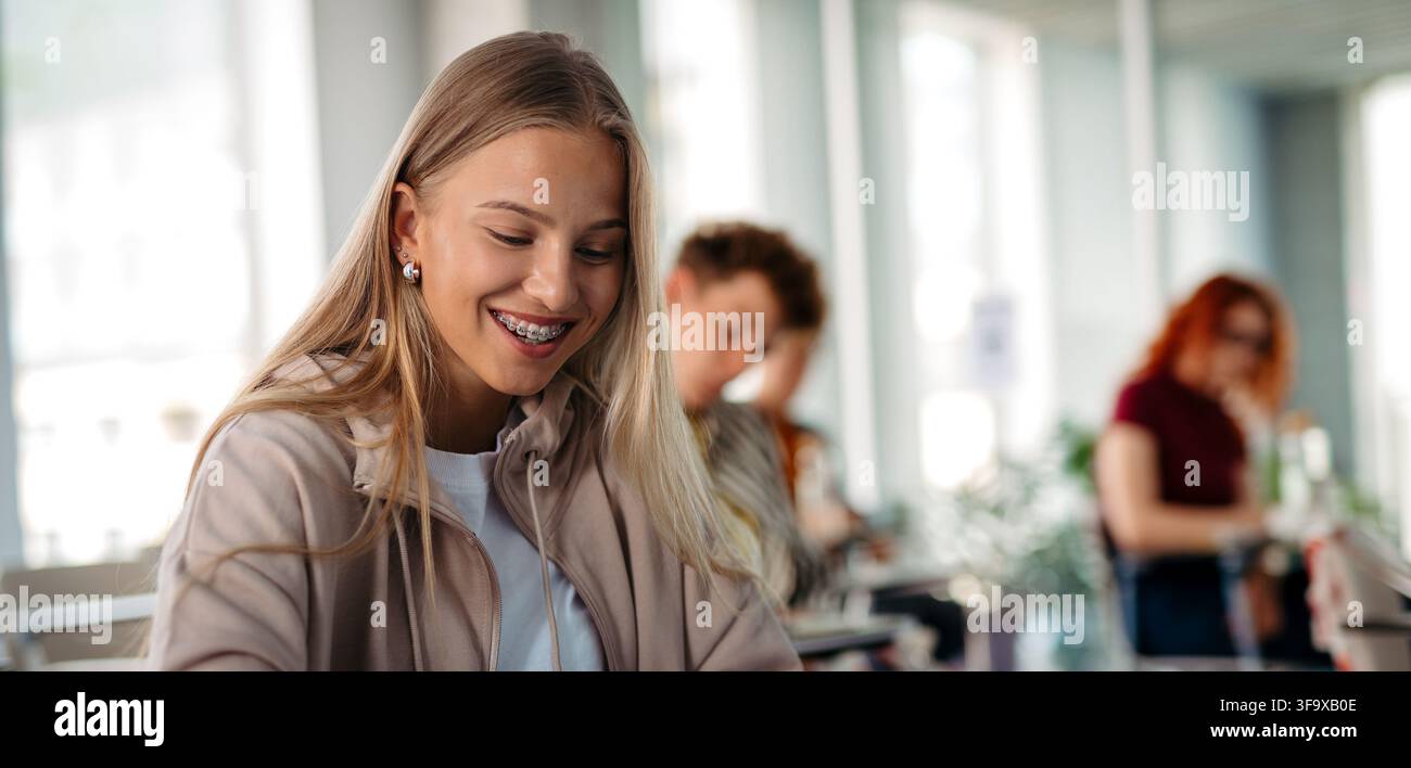 Female student writing notes during university lecture. Stock Photo