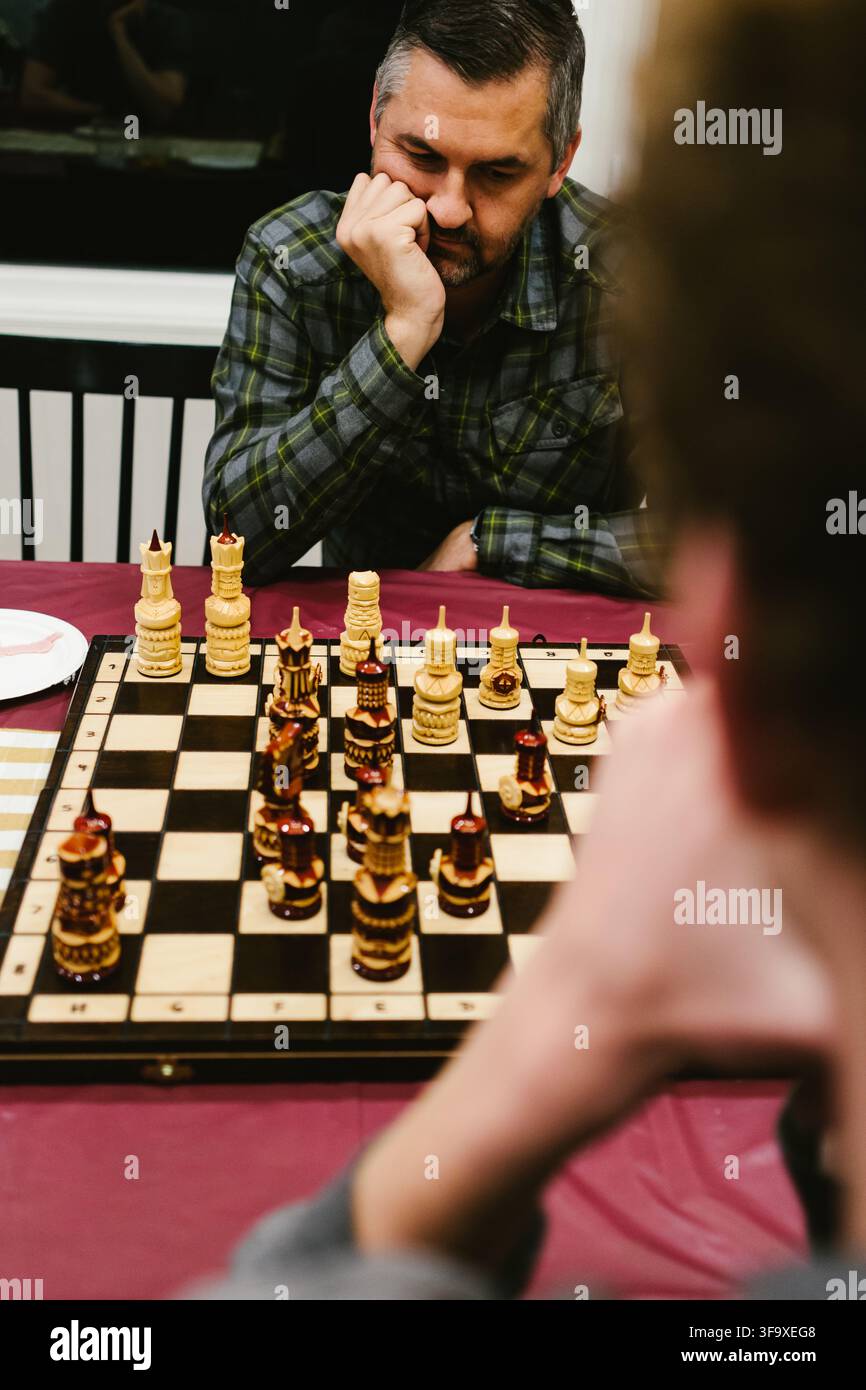 Man contemplates his next move in chess game Stock Photo