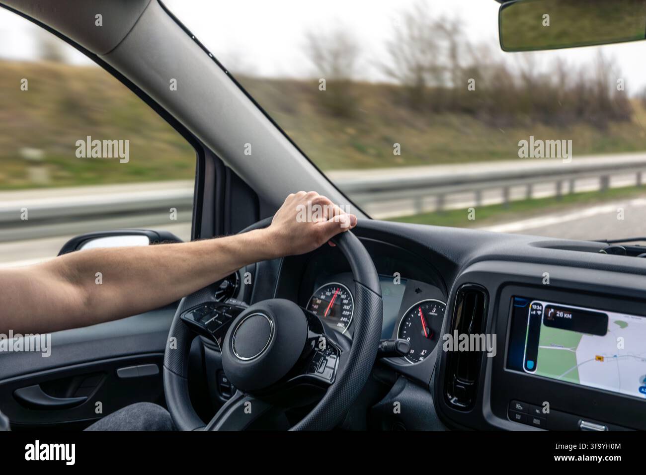 Driver Hand On Steering Wheel With Navigation Screen Stock Photo