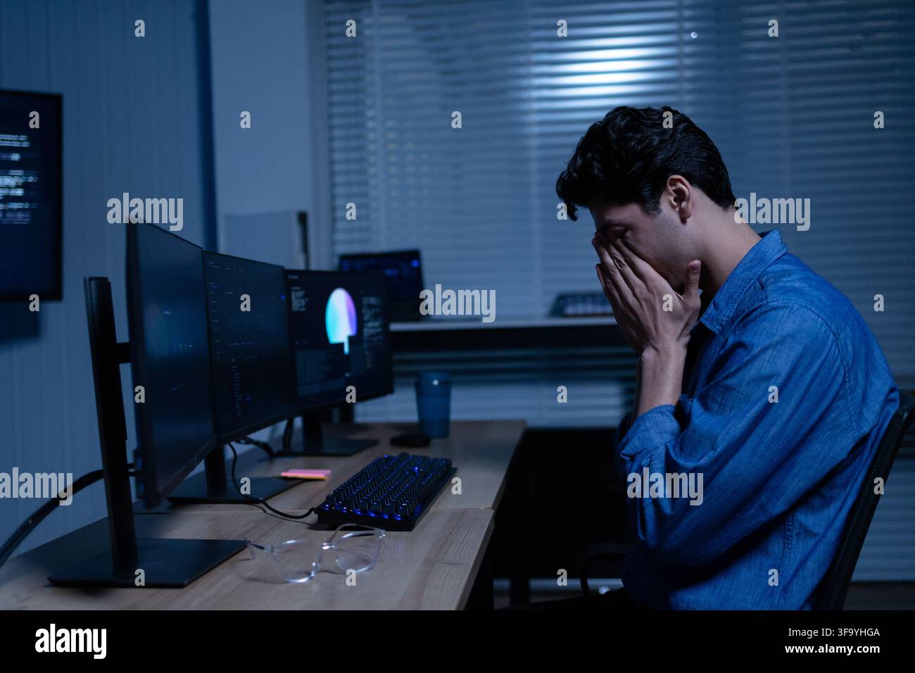 Tired Young Professional Working Late At Computer Stock Photo