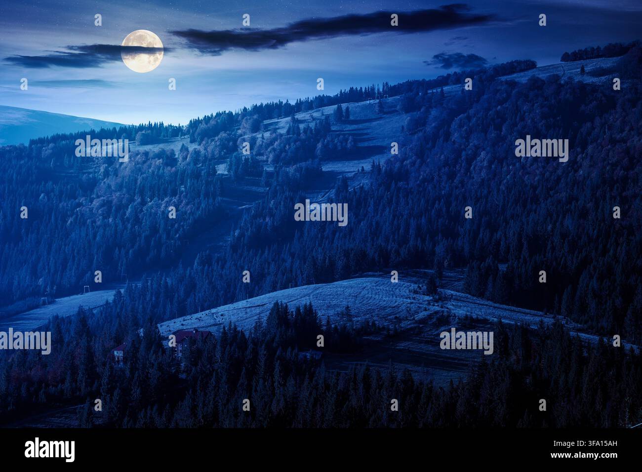 mountainous rural landscape of ukraine in autumn at night. full moon over picturesque highland woods. grassy meadow. carpathian countryside scenery wi Stock Photo