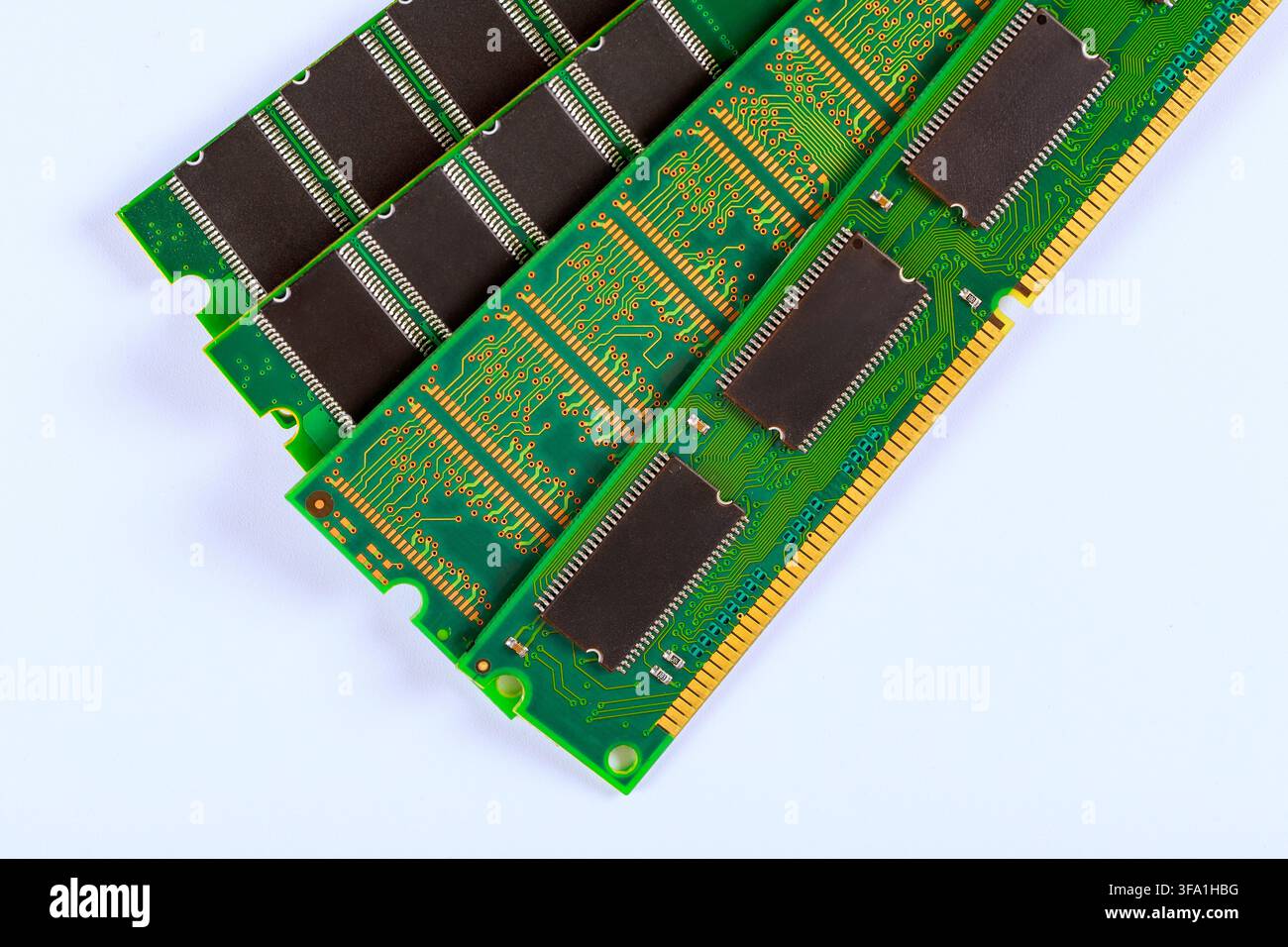 Memory chips are placed in rows on green circuit board surfaces with intricate electronic patterns, Stock Photo
