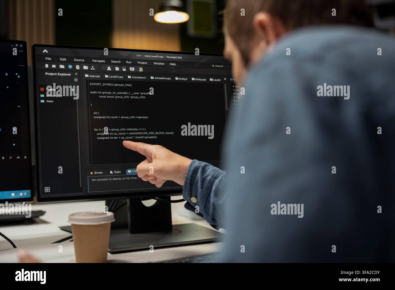System administrator in startup office optimizing code for performance and scalability, doing quality assurance. IT worker following programming language written on PC screen with finger Stock Photo