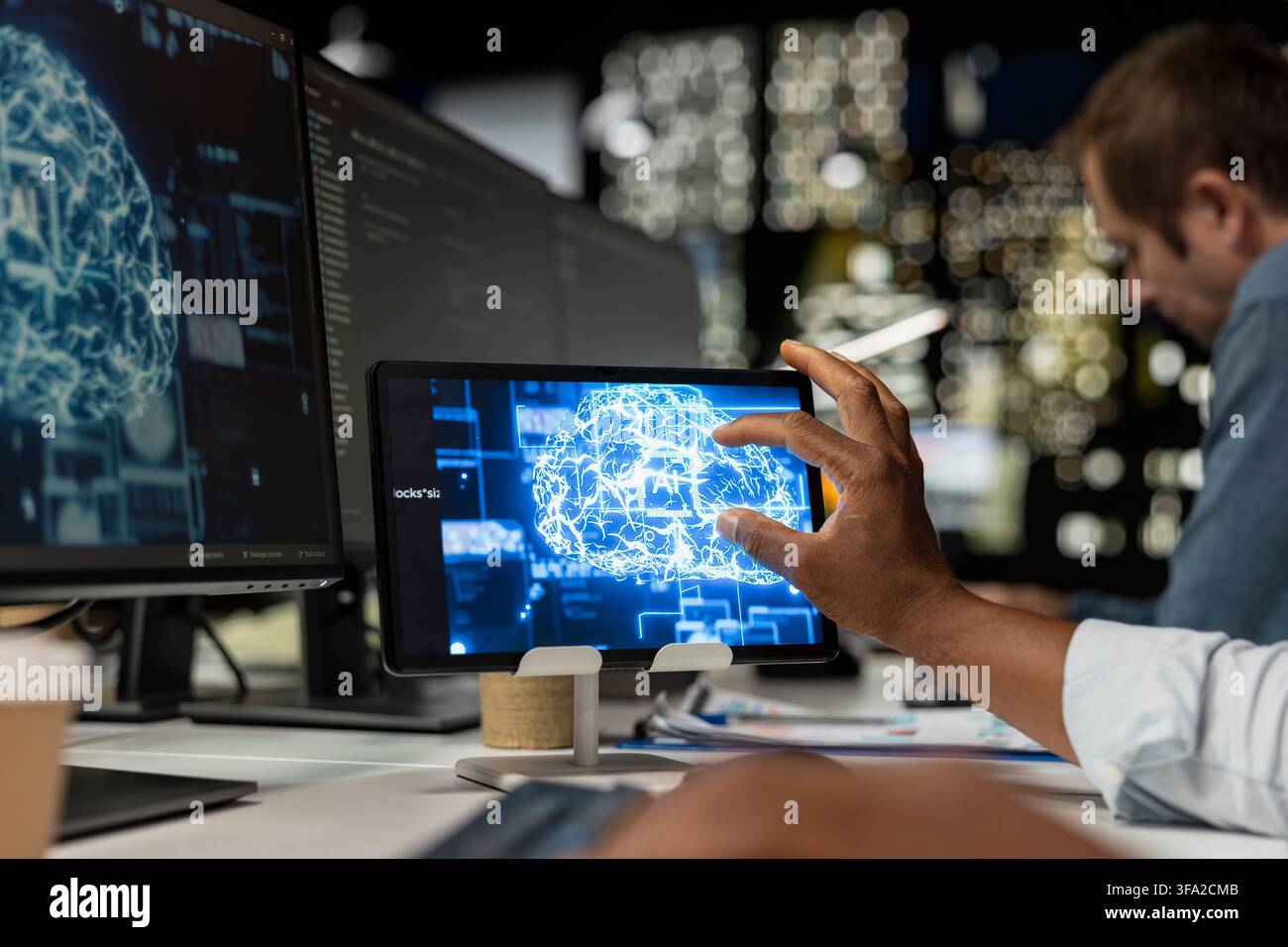 Technician utilizing AI on tablet to optimize performance and forecast issues. IT specialist in tech company office training deep learning models on device to perform automatic updates Stock Photo