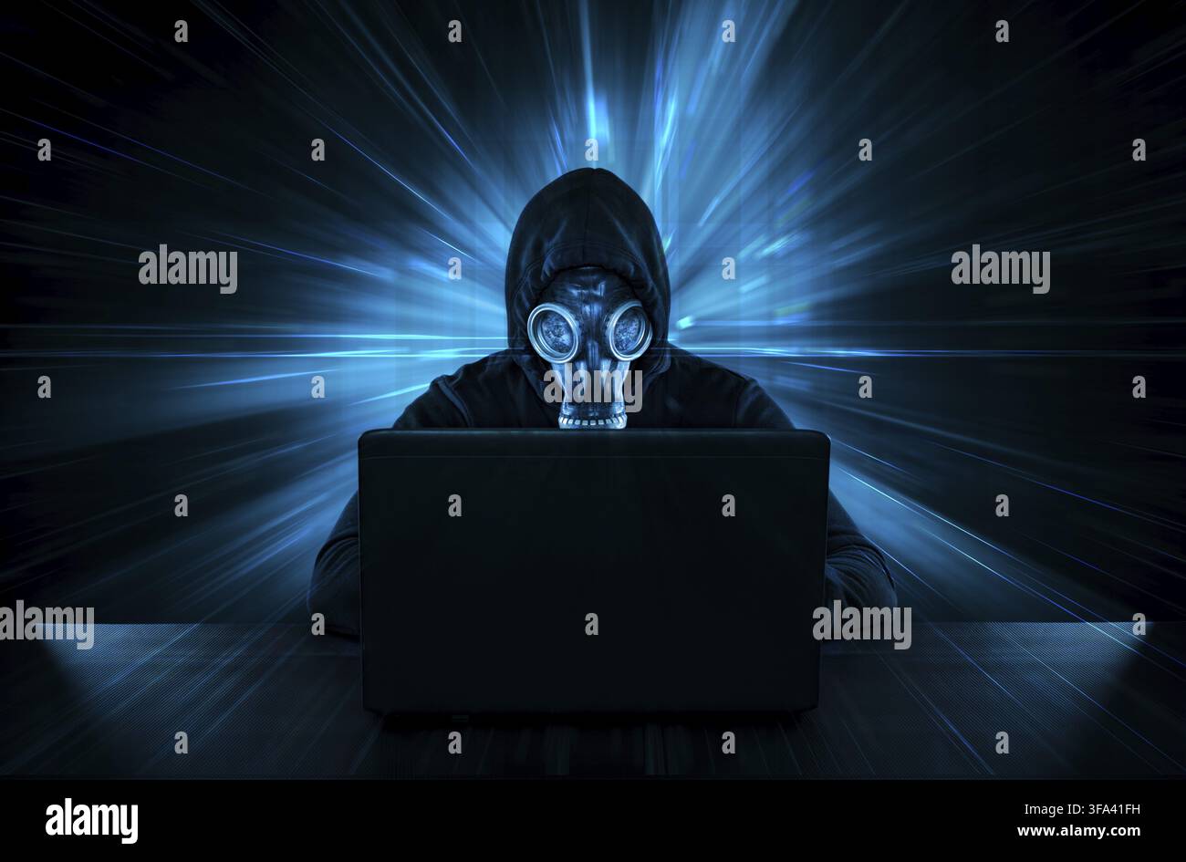 Male thief in gas mask stealing data from computer Stock Photo