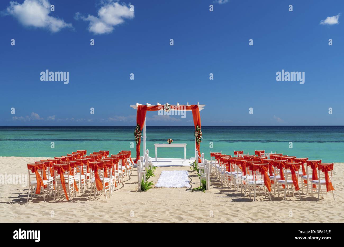 Romantic Wedding setting up with red decorations on the beach Stock Photo