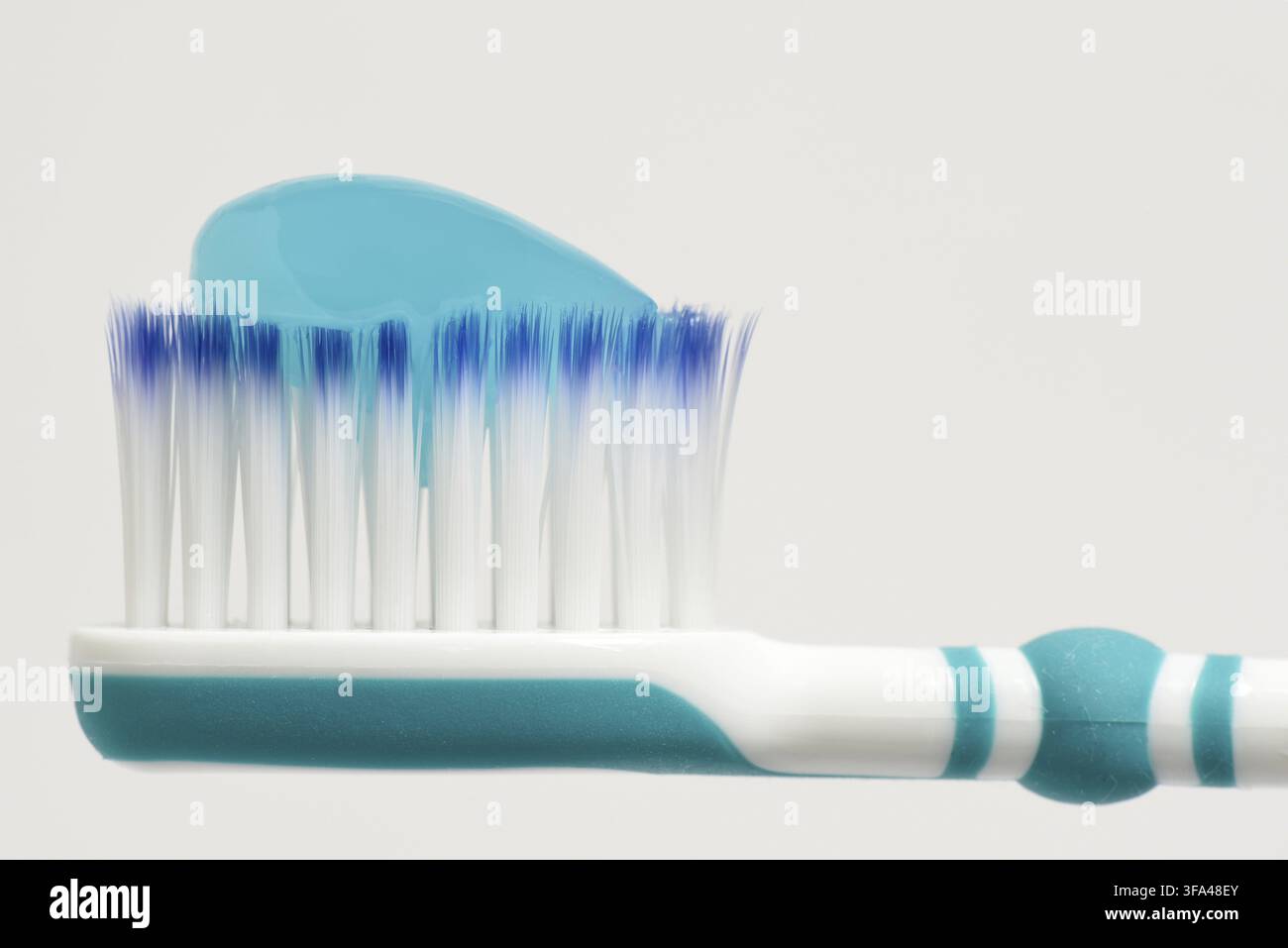 Toothbrush head with blue toothpaste on Stock Photo