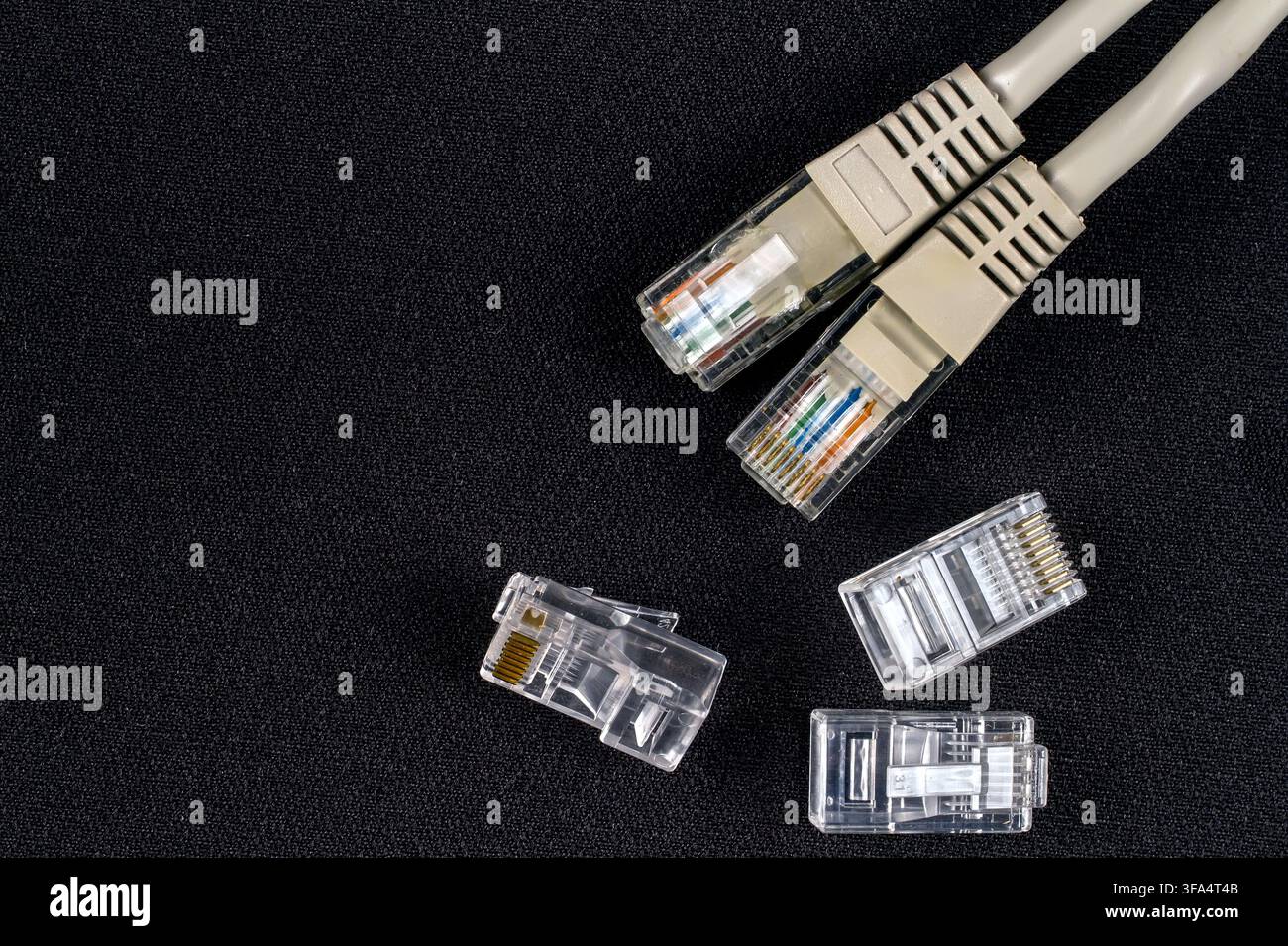 Network cable with connectors. Close-up connectors on a black background. Stock Photo