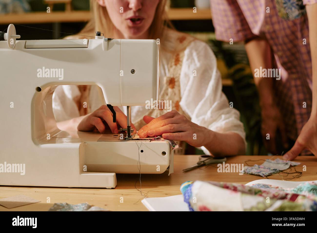 Woman Using Sewing Machine during Creative Workshop Class Stock Photo