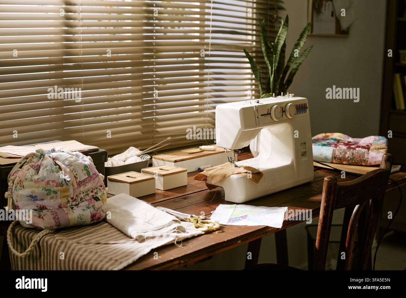 Sewing Machine on Wooden Table in Creative Craft Workshop Stock Photo
