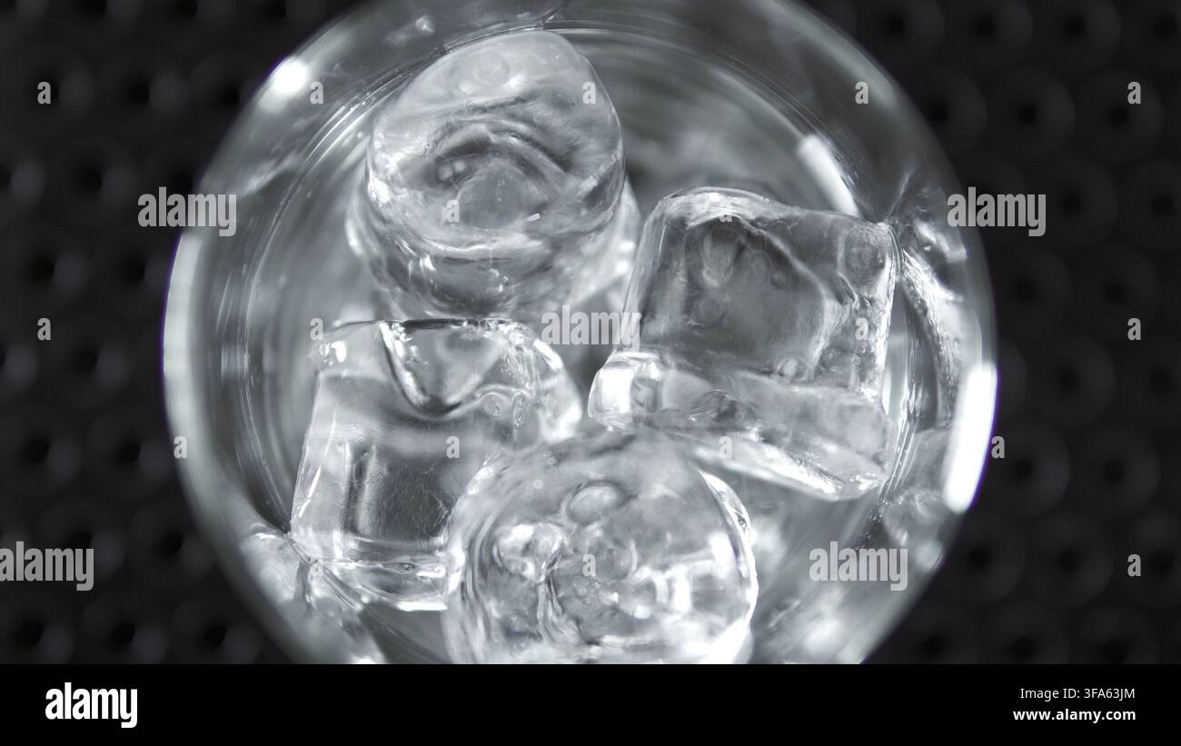 Ice cubes chilling a drink inside a glass, creating a refreshing, cold beverage. Abstract background pattern Stock Photo