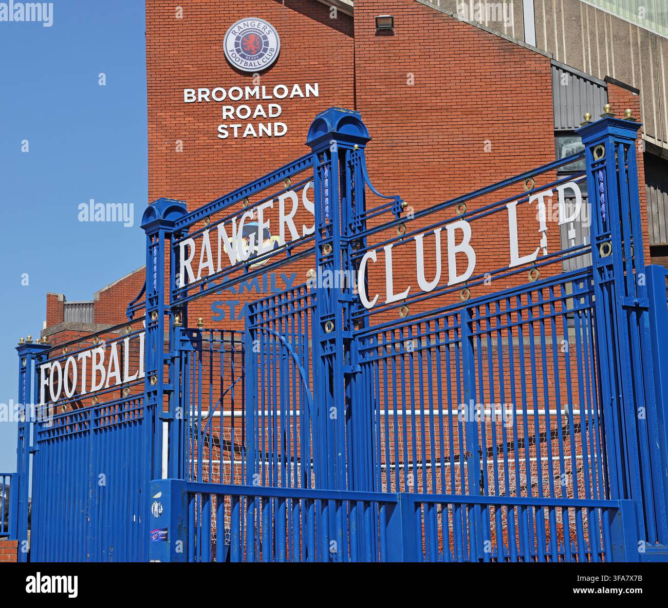 Ornate blue Glasgow Rangers FC iron gates and Broomloan Road Stand at historic Ibrox Stadium, home of Rangers in Glasgow, Scotland. Stock Photo