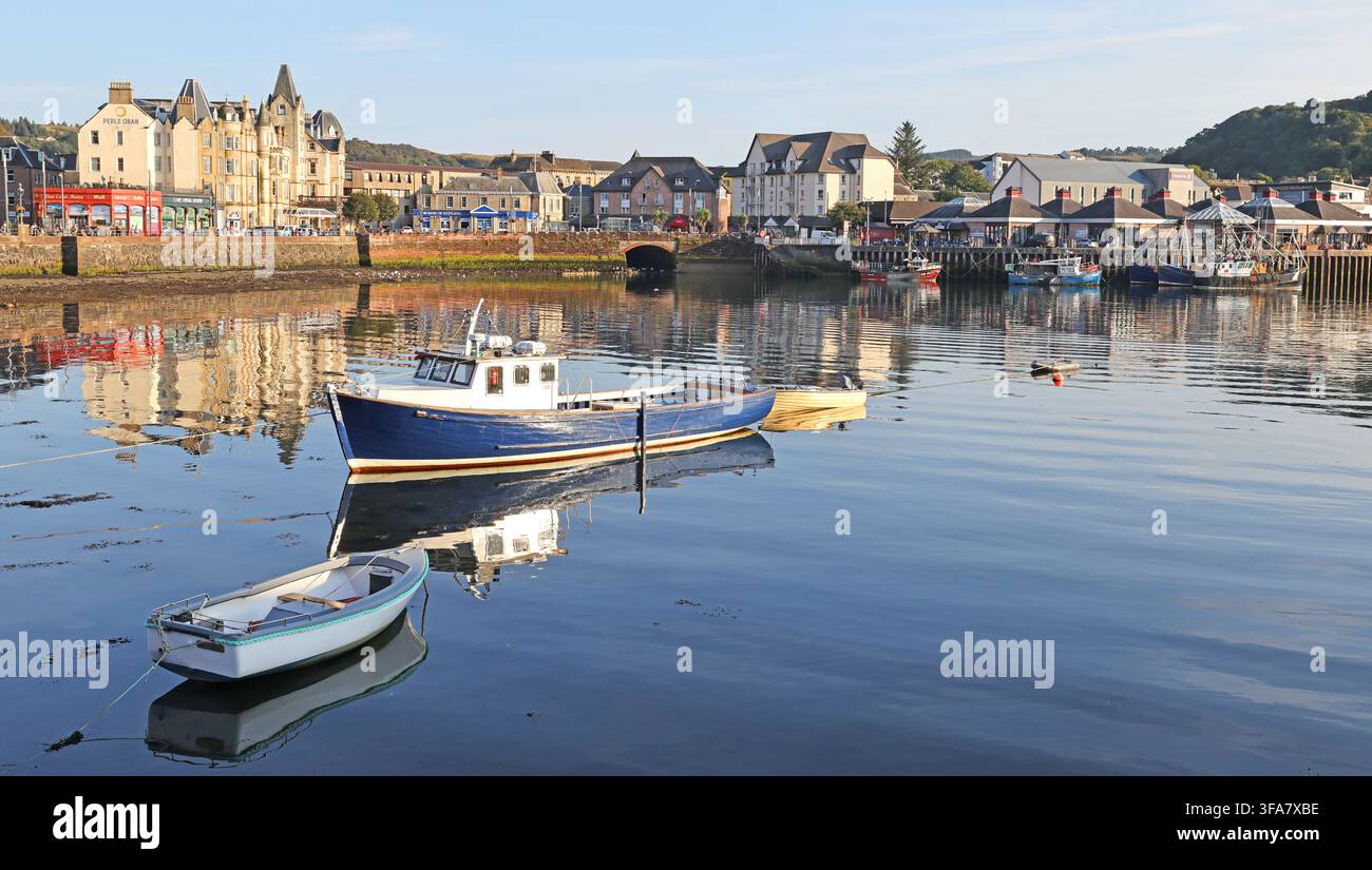 Small boats moored on calm water in Oban harbour, Scotland Stock Photo