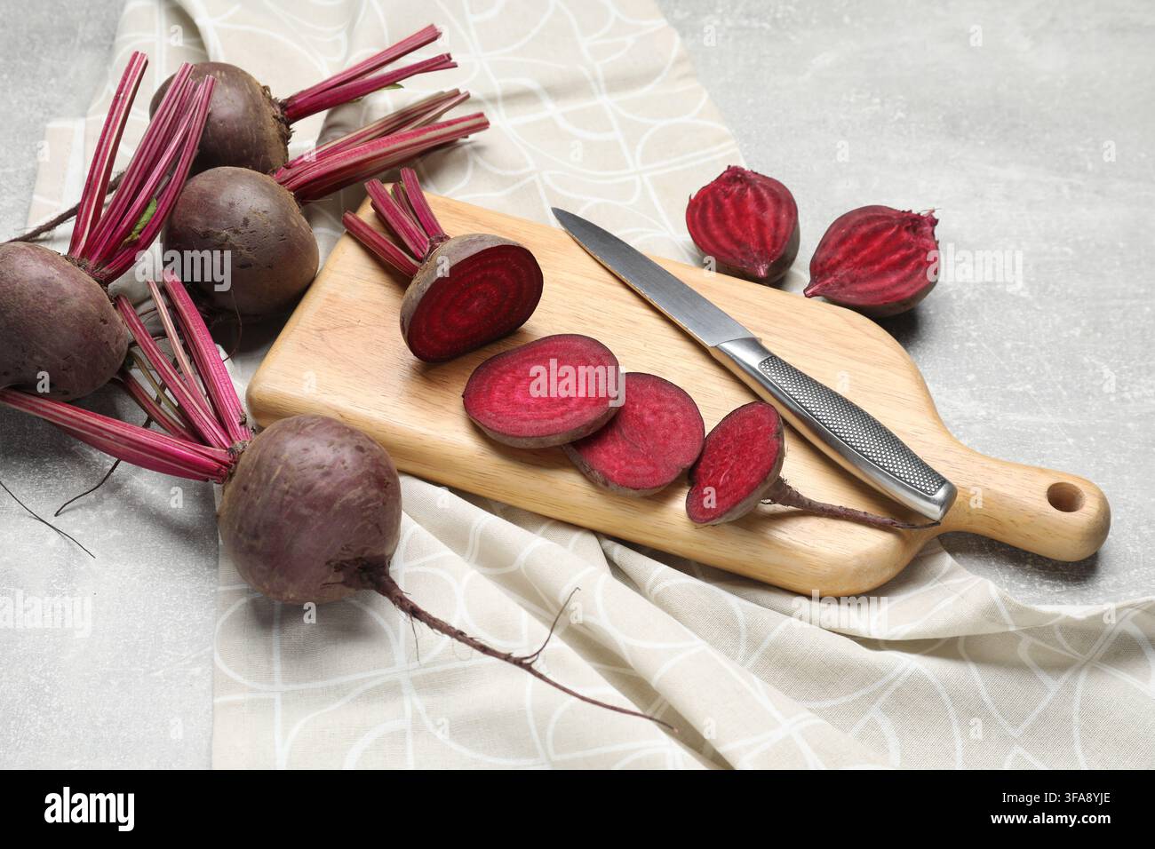 Fresh young beets and knife on gray textured table, closeup Stock Photo