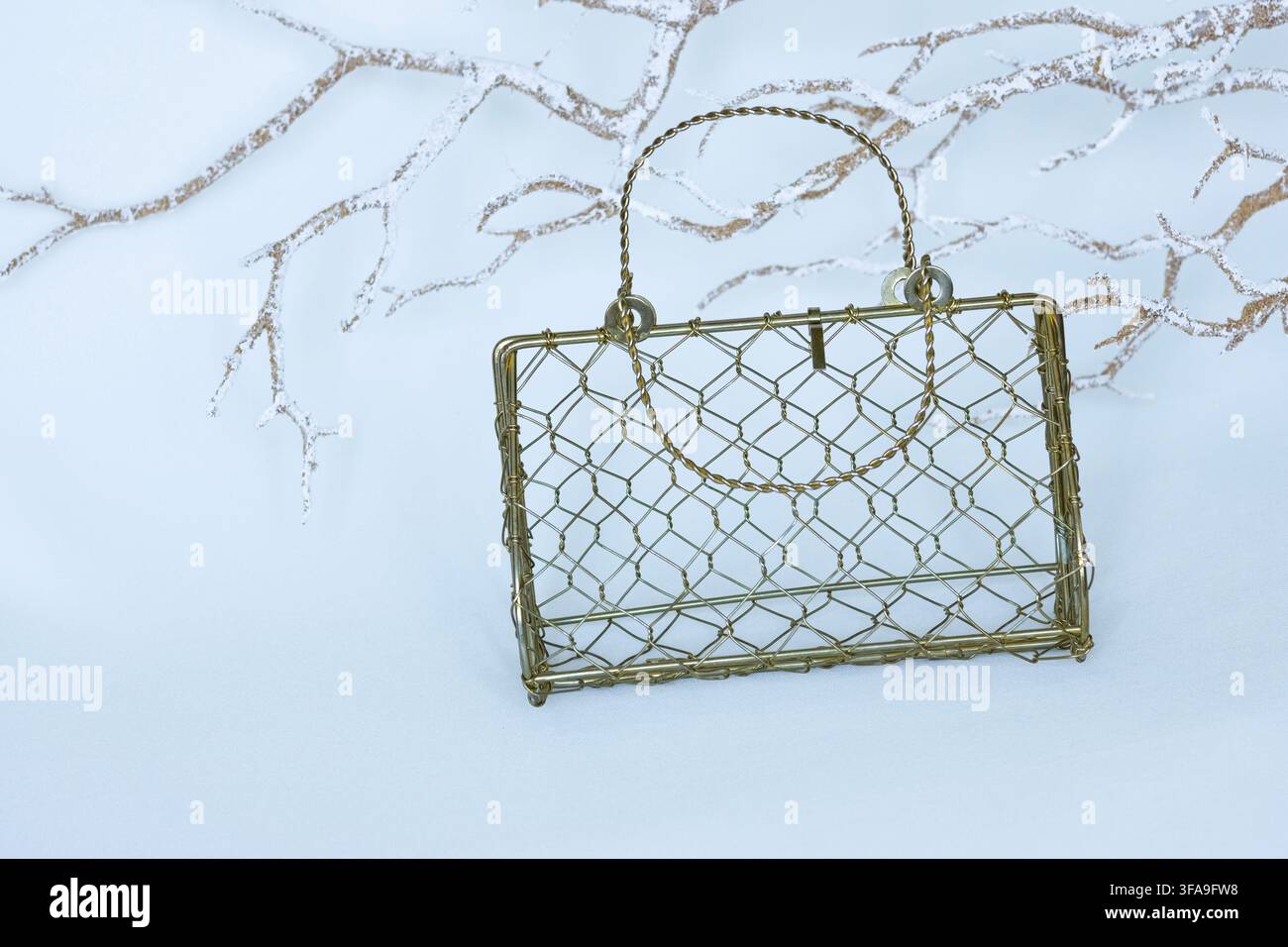 Vintage Gold Wire Handbag on White Background with Decorative Frosted Branches and Copy Space Stock Photo