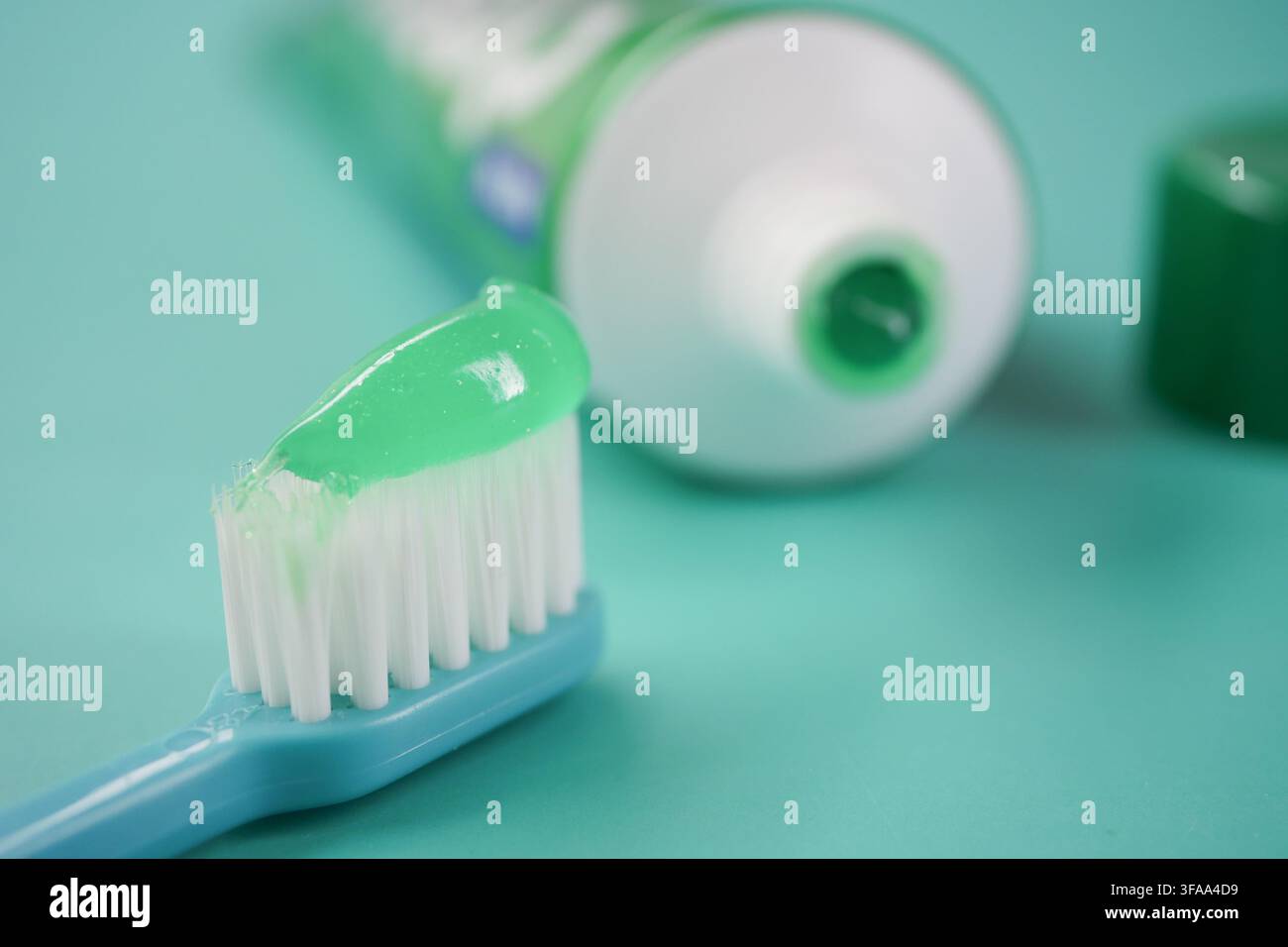 Toothbrush with green toothpaste on blue background Stock Photo