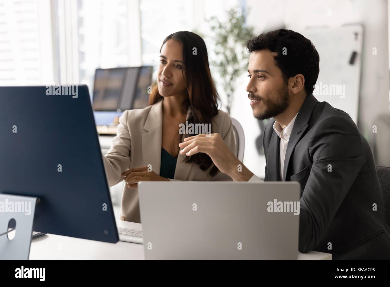 Diverse coworkers collaborating on strategy using computer in office Stock Photo