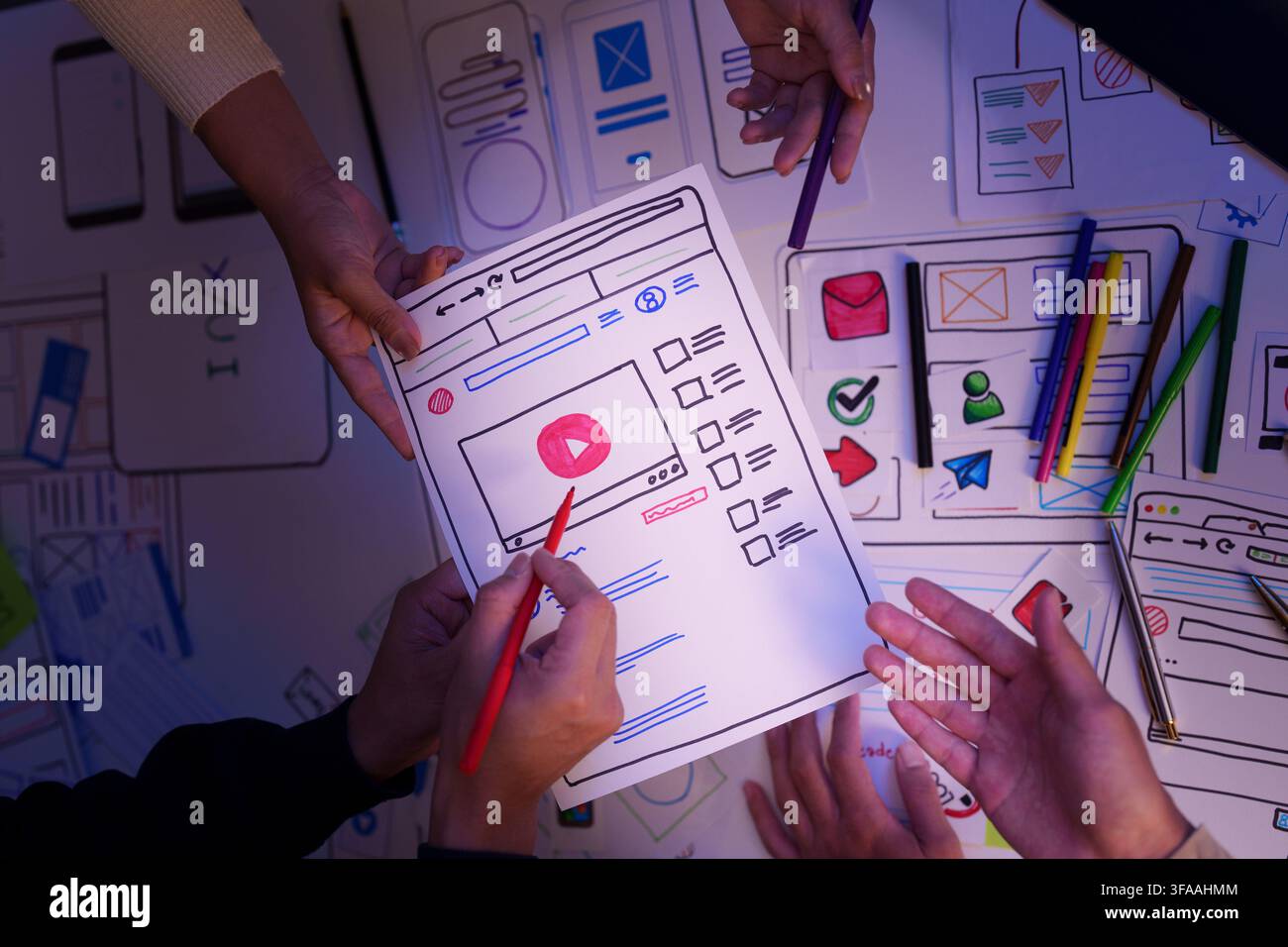 Creative UX UI design team reviewing video app wireframe prototype on paper Stock Photo