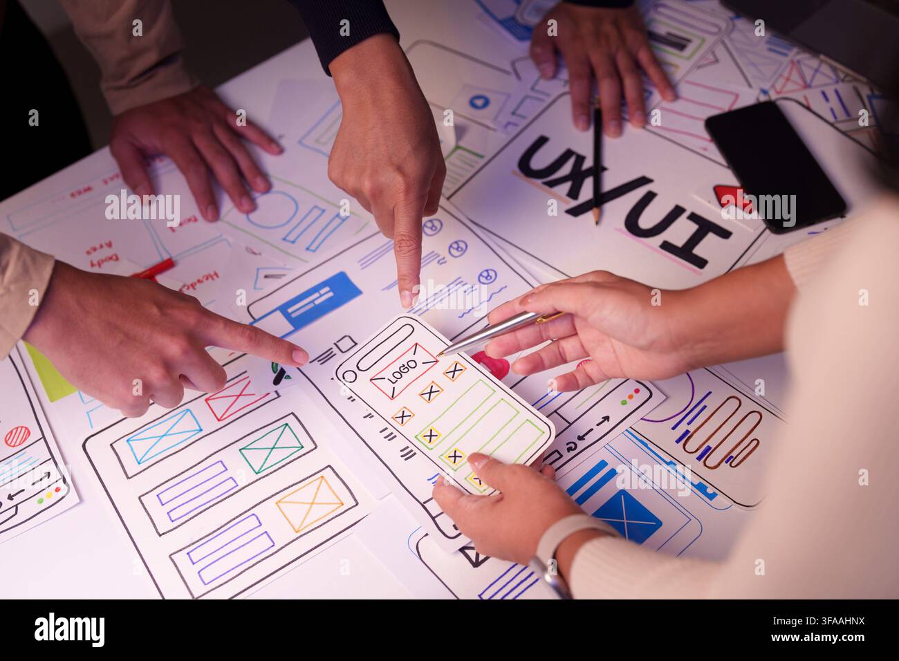 UX UI designers collaborating on mobile app wireframe sketches during workshop Stock Photo