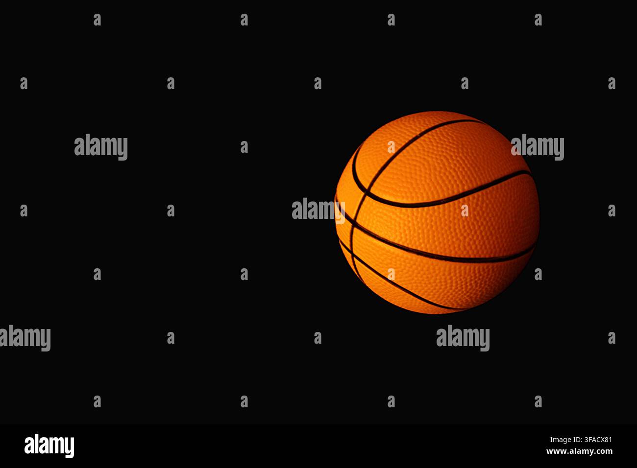 Basketball on solid black background with dramatic lighting and copy space Stock Photo