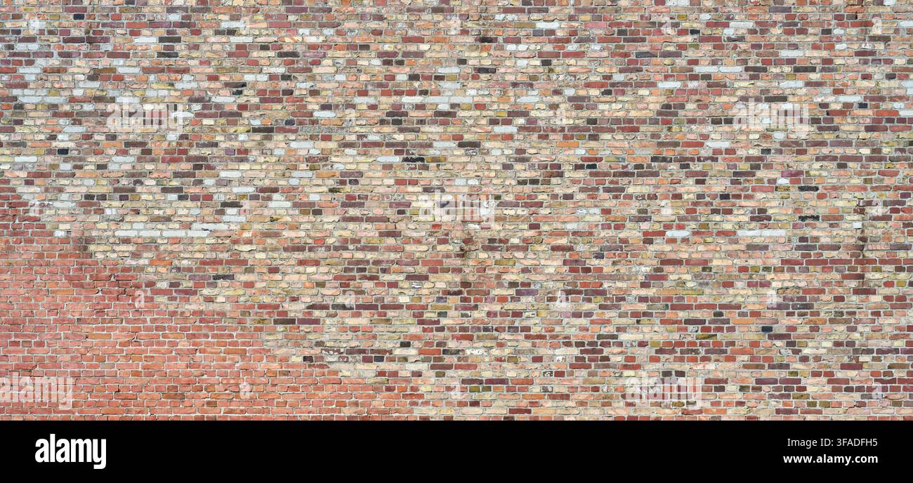 Huge old brick wall made of many bricks in various colors Stock Photo