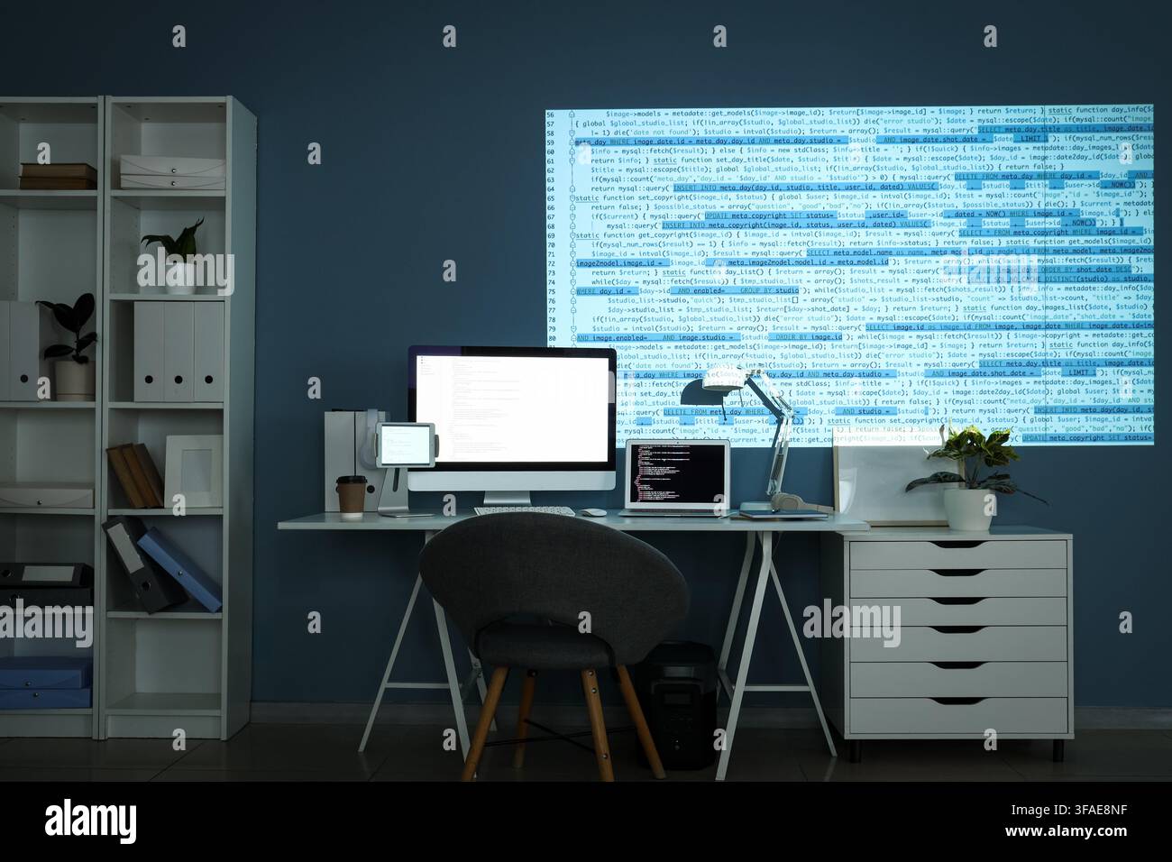 Software development and coding at night, programmer working late with multiple screens and projected code on wall Stock Photo