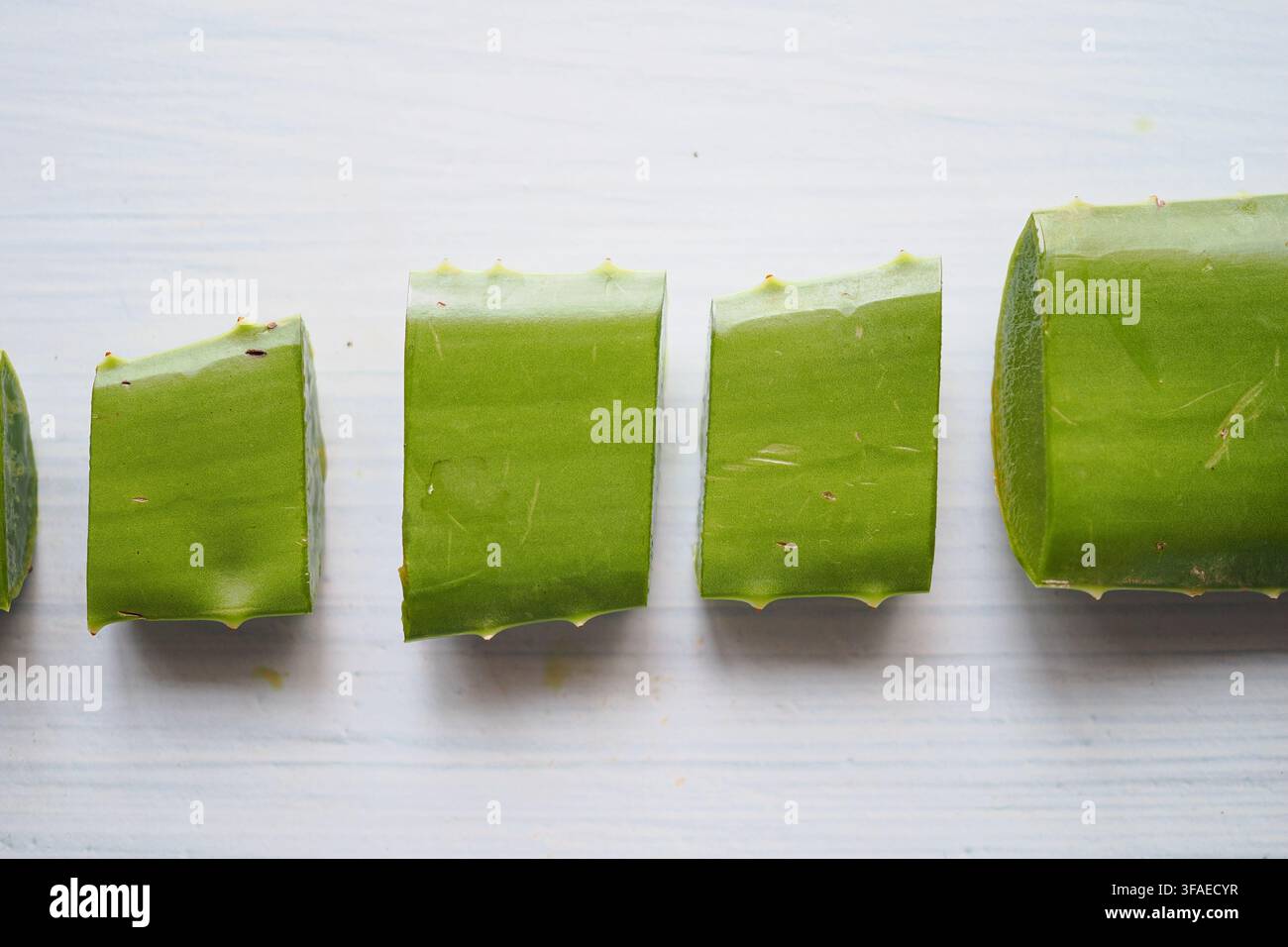 Sliced aloe vera leaves arranged on a white surface Stock Photo