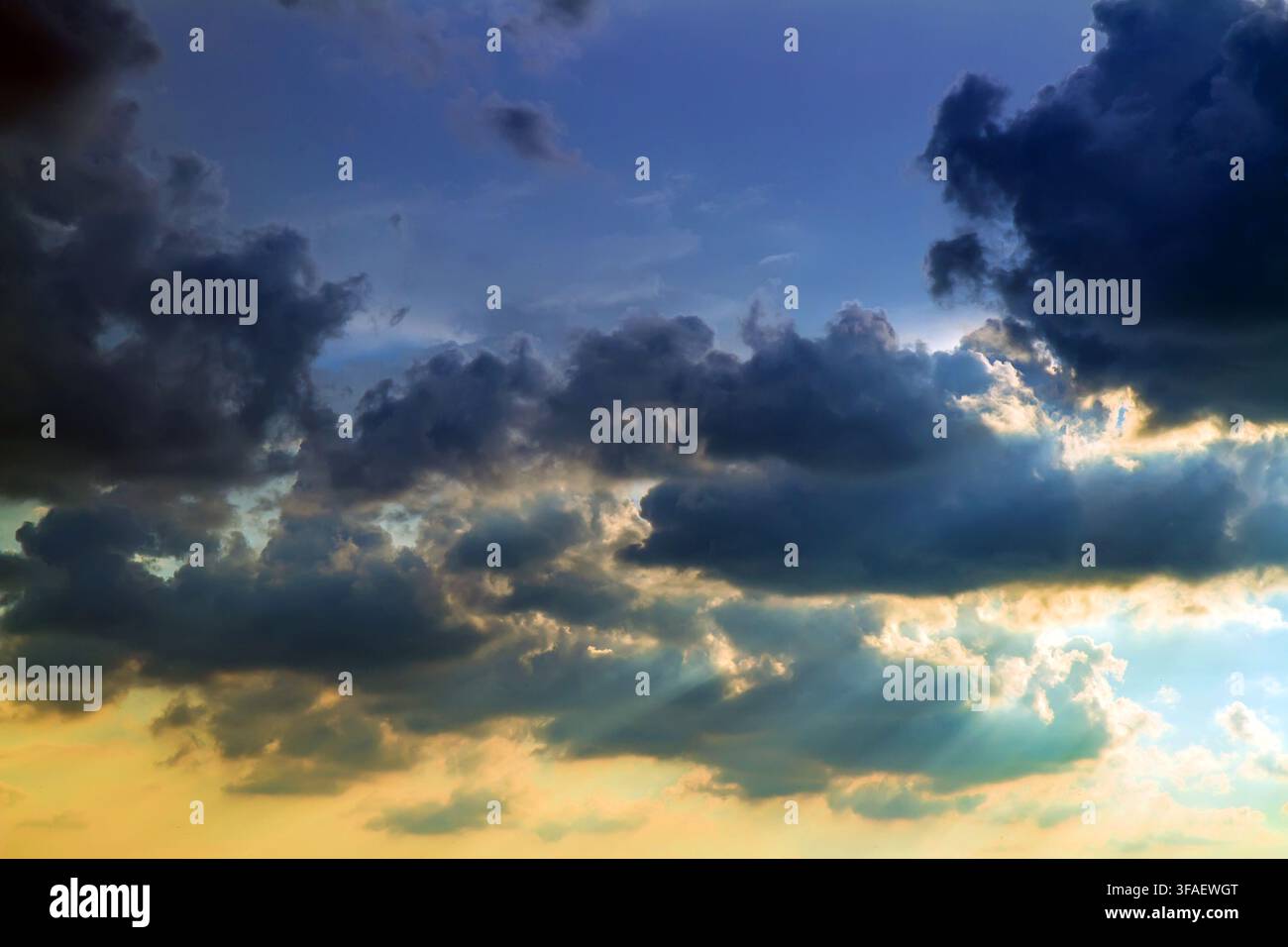 Dramatic sky at sunset. Dark cumulus clouds. Stock Photo