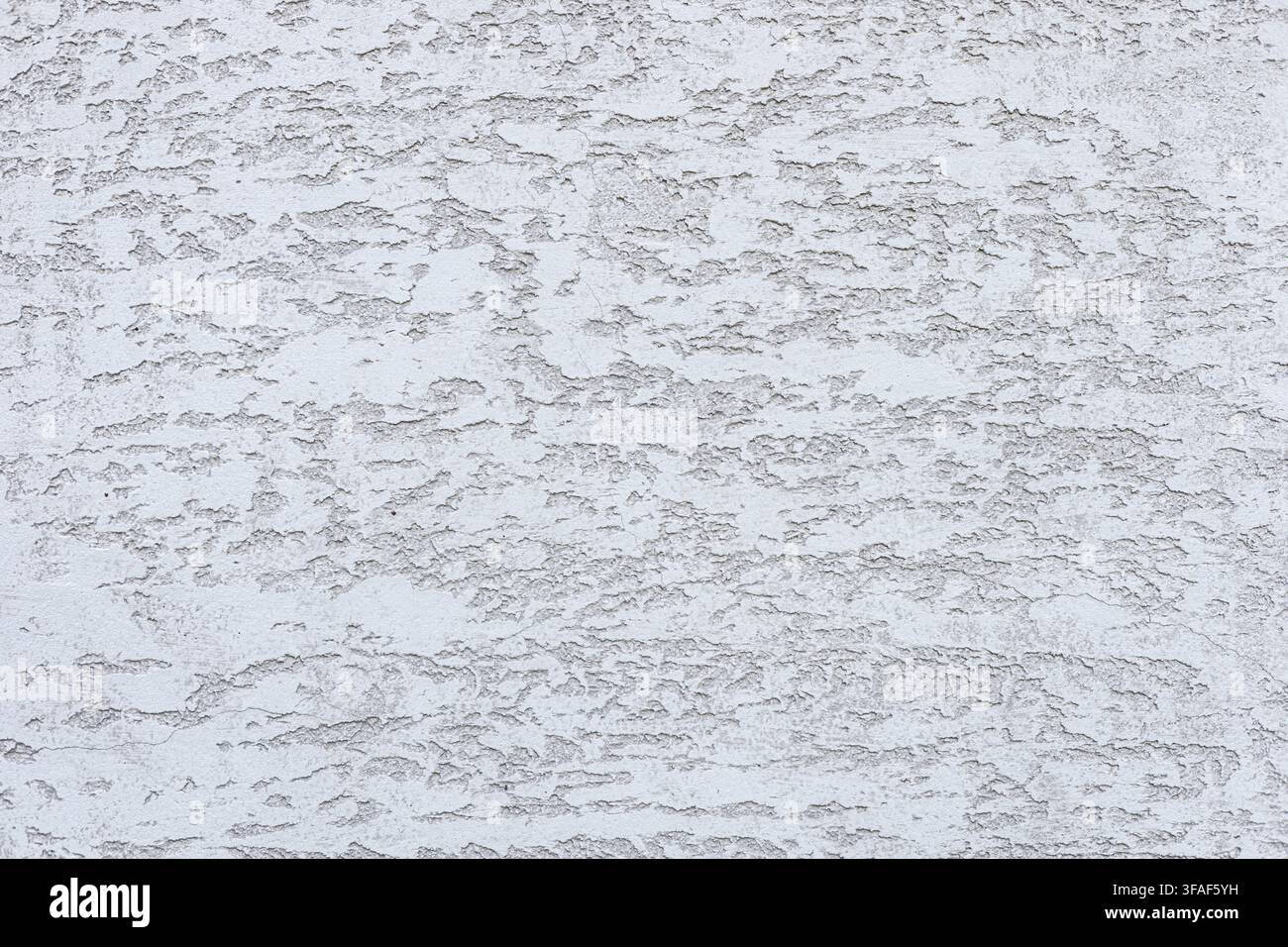 Textured white wall with subtle patterns and variations. The surface appears rough and uneven, creating an interesting visual effect Stock Photo