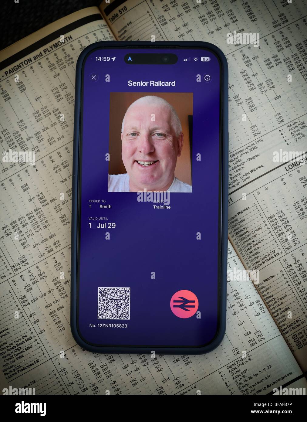 Senior digital Railcard displayed on a smartphone over a railway map, showing the three-year UK discount card for older train passengers. Stock Photo