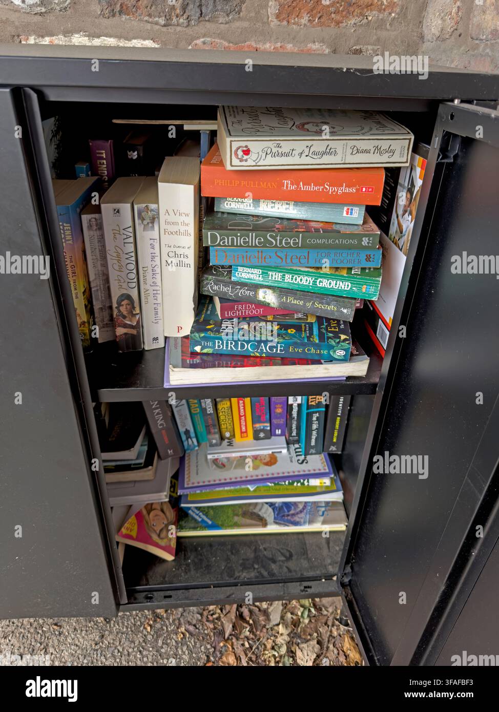 Books inside the Wright's Green community book share at Appleton Thorn, a free local mini-library supported by the parish community. Stock Photo