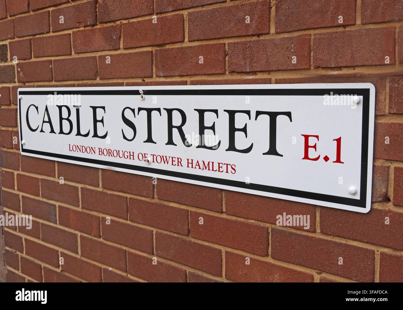 Traditional Cable Street E1 enamel-style street sign for the London Borough of Tower Hamlets, East London, England, UK. Stock Photo